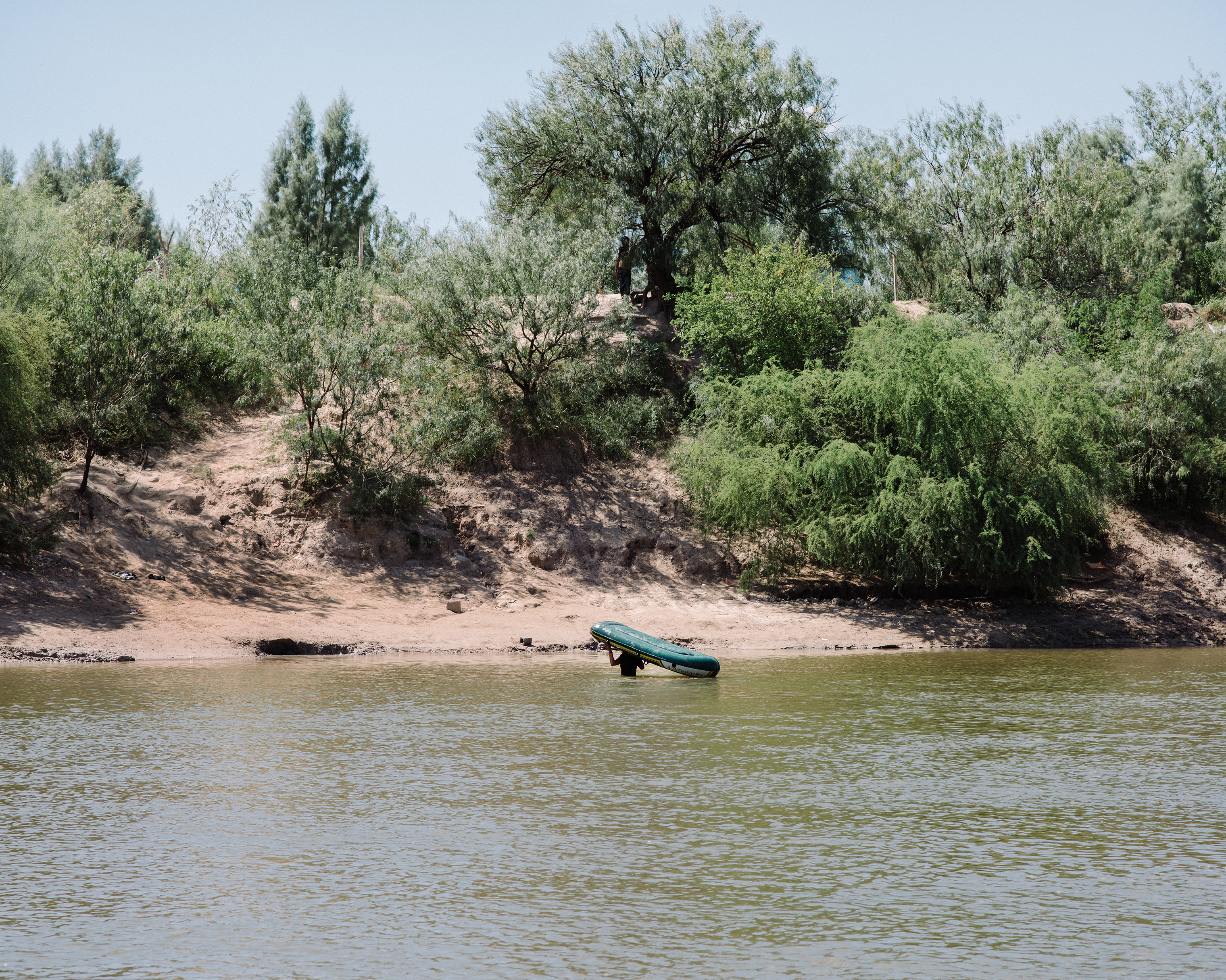 A trafficker returns to the Mexican side of the Rio Grande after paddling over two Nicaraguans on Sept. 25. (John Francis Peters for TIME)