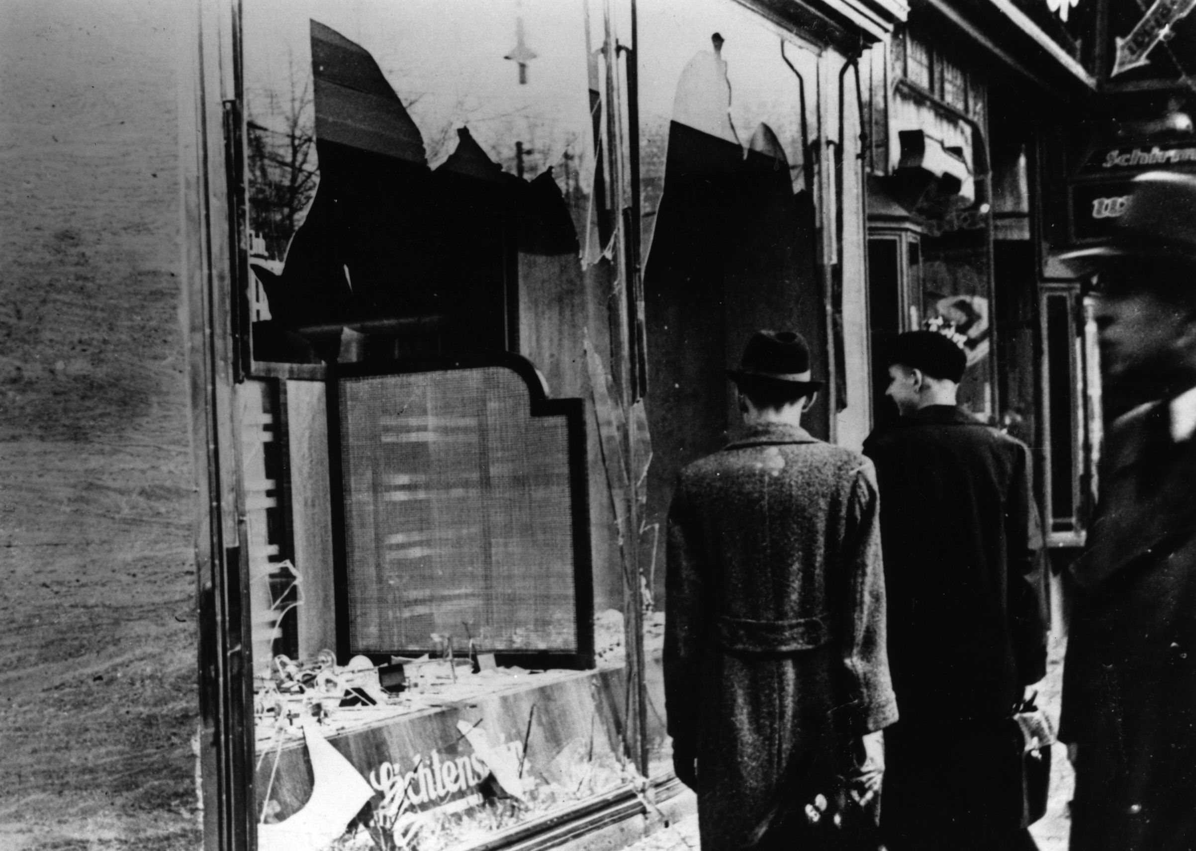 Nov. 10, 1938:  Three onlookers at a smashed Jewish shop window in Berlin following riots of the night of 9th November. (Hulton Archive/Getty Images)