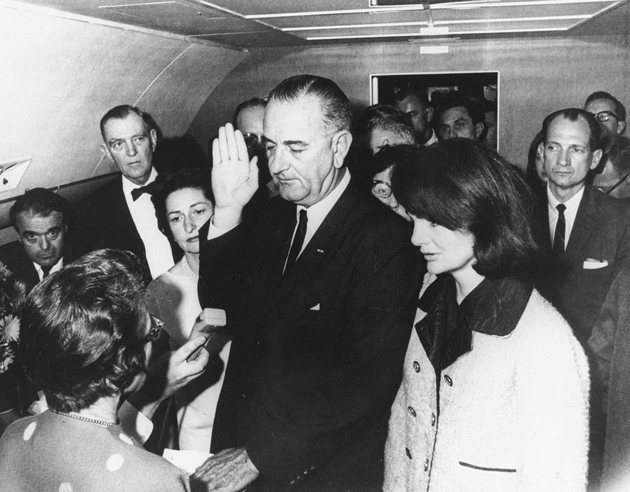 Lyndon B. Johnson is sworn in as President by federal Judge Sarah T. Hughes on Air Force One on Nov. 22, 1963, in Dallas, following the assassination of President John F. Kennedy. He's flanked by Jacqueline Kennedy (right) and wife Lady Bird Johnson (left). (Cecil Stoughton-WH Photographs/AFP—Getty Images)