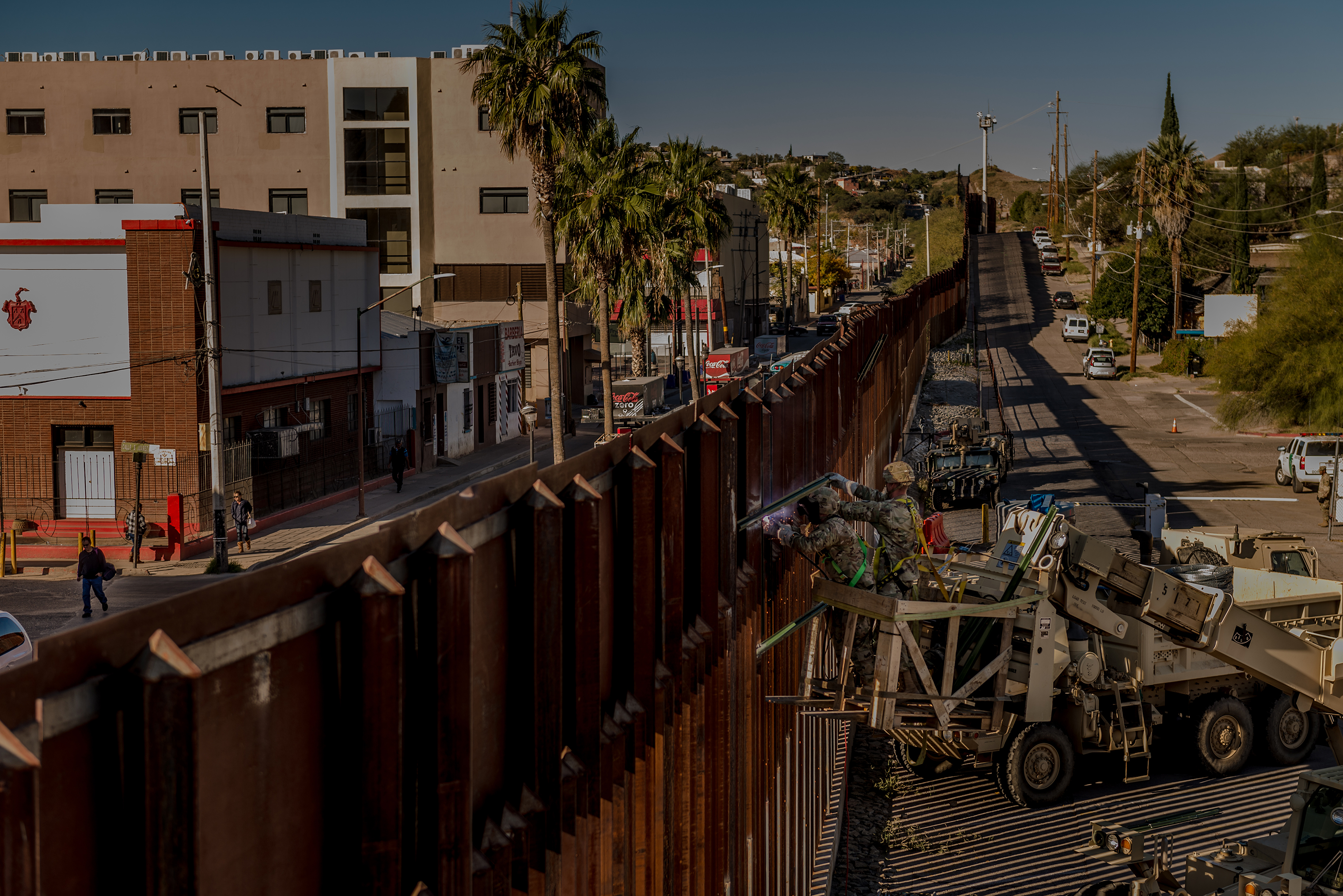 Soldiers of the 104th Engineer Construction Company weld brackets along the border wall in Nogales, Ariz. (Meridith Kohut for TIME)
