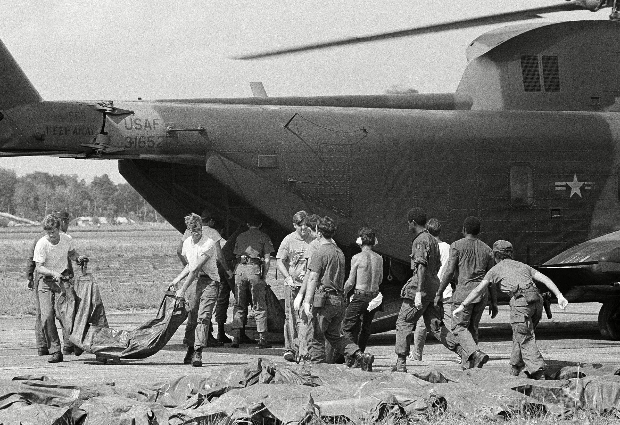 Bodies of victims of Jonestown mass suicide are loaded from U.S. military helicopter at Georgetown's international airport. The corpses, in body bags, will be transferred to shipping containers for the flight back to the U.S. (AP/Shutterstock)