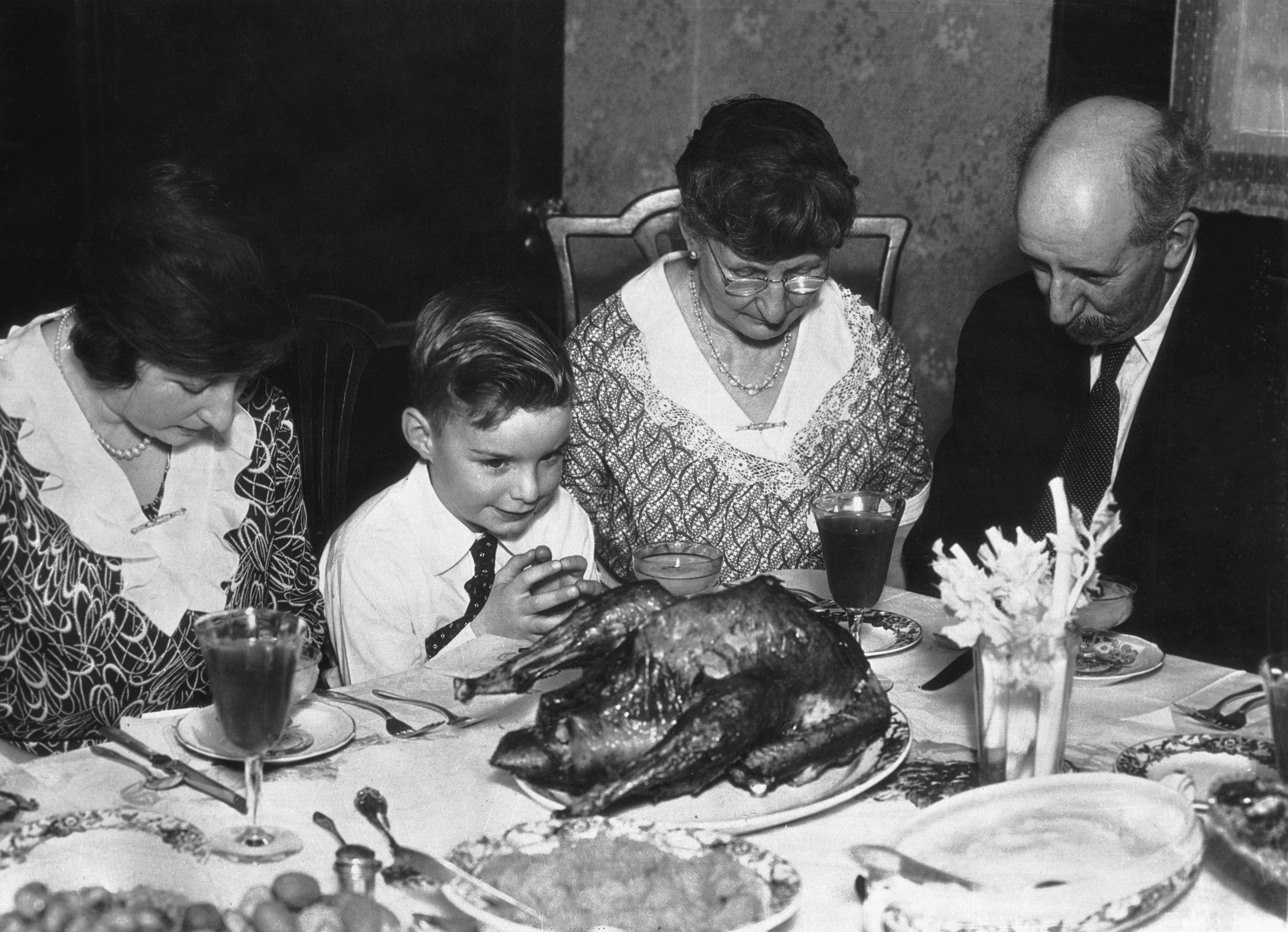 A family saying grace before Thanksgiving dinner. Ca. 1930s. (Bettmann/Getty Images)