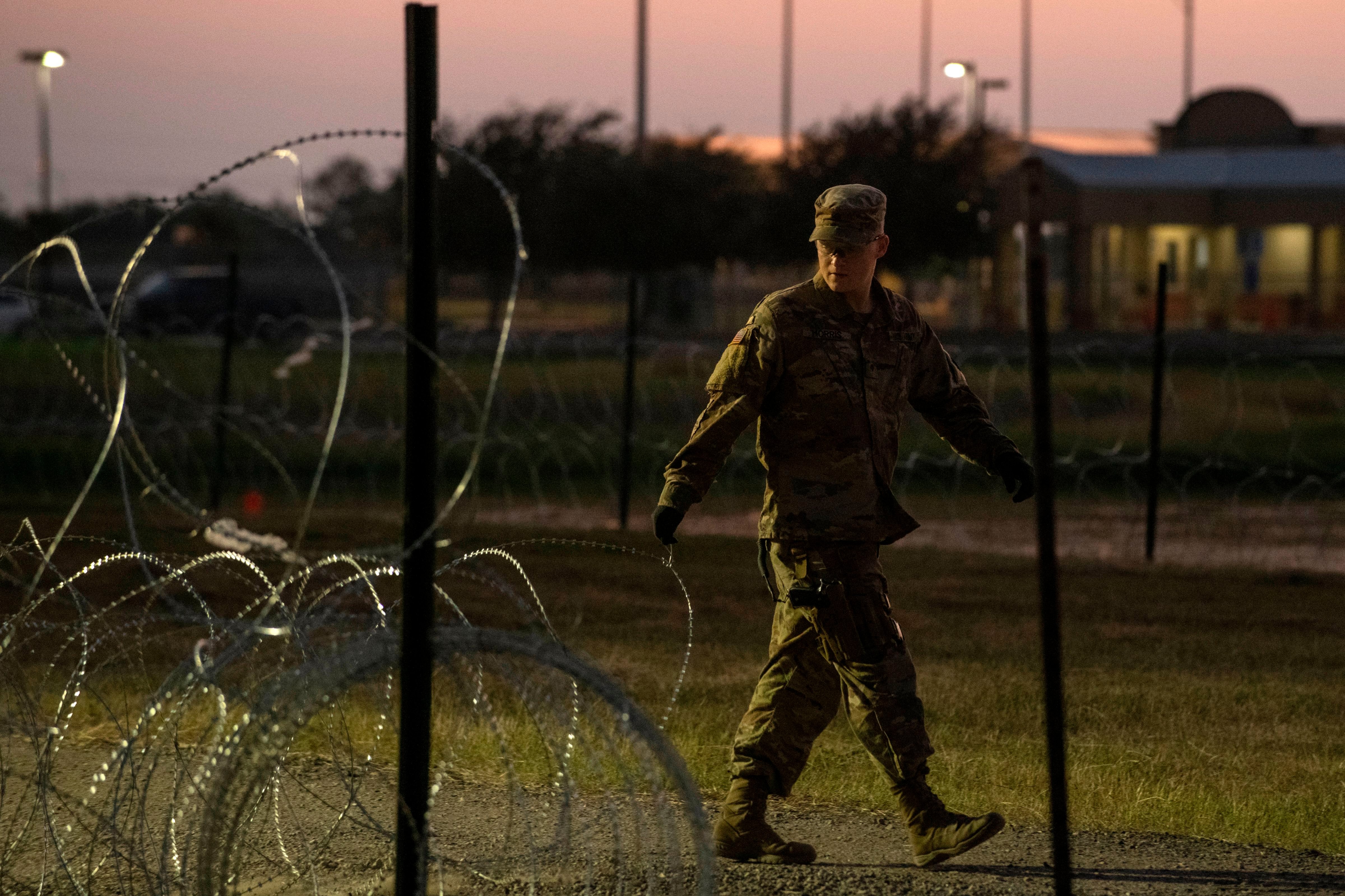 A US Army soldier closes a razor-wire gate at a compound where the military is erecting an encampment near the US-Mexico border crossing at Donna, Texas, on November 6, 2018. (ANDREW CULLEN&mdash;AFP/Getty Images)