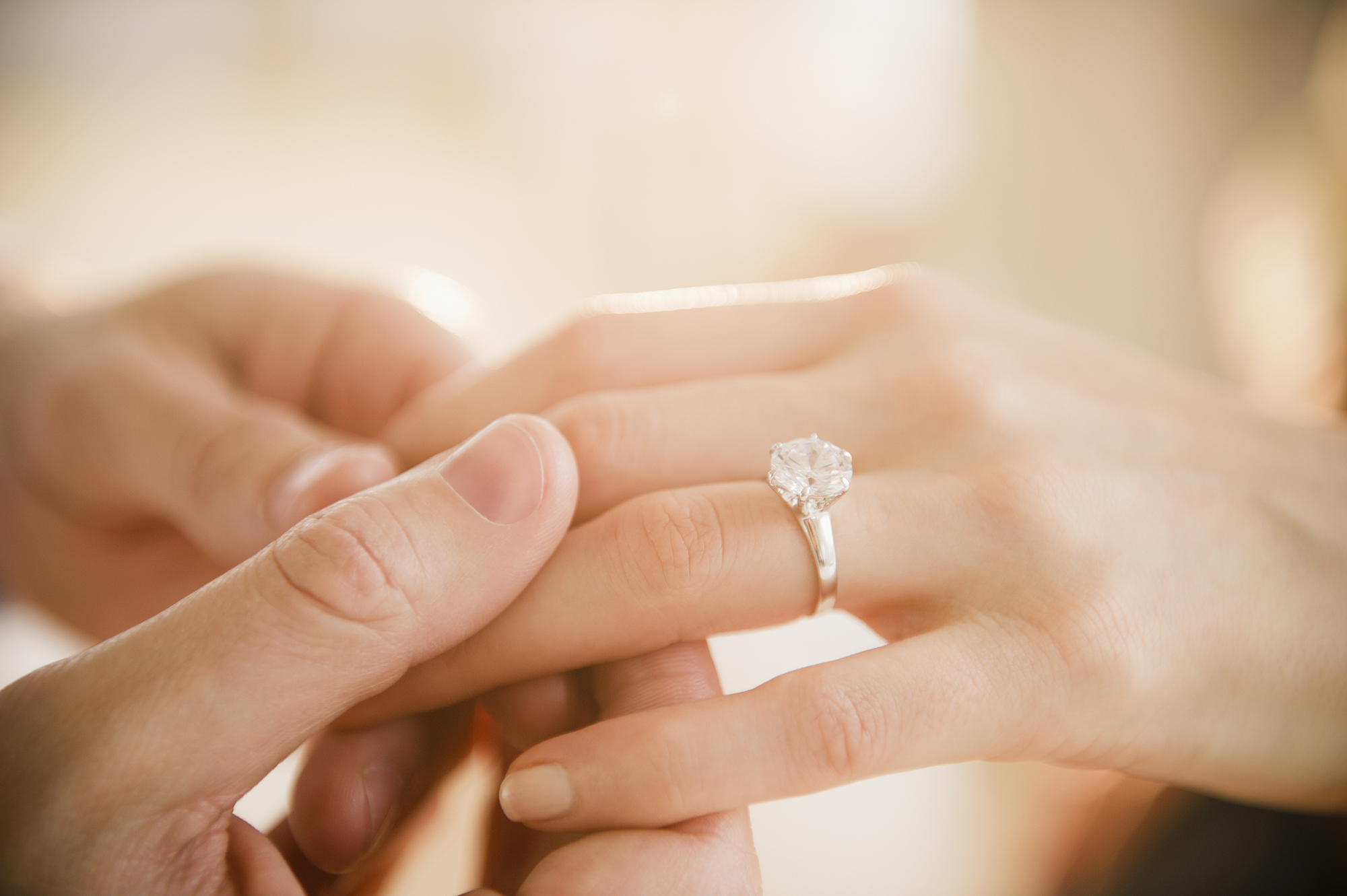 USA, New Jersey, Jersey City, Close up of man's and woman's hands with engagement ring