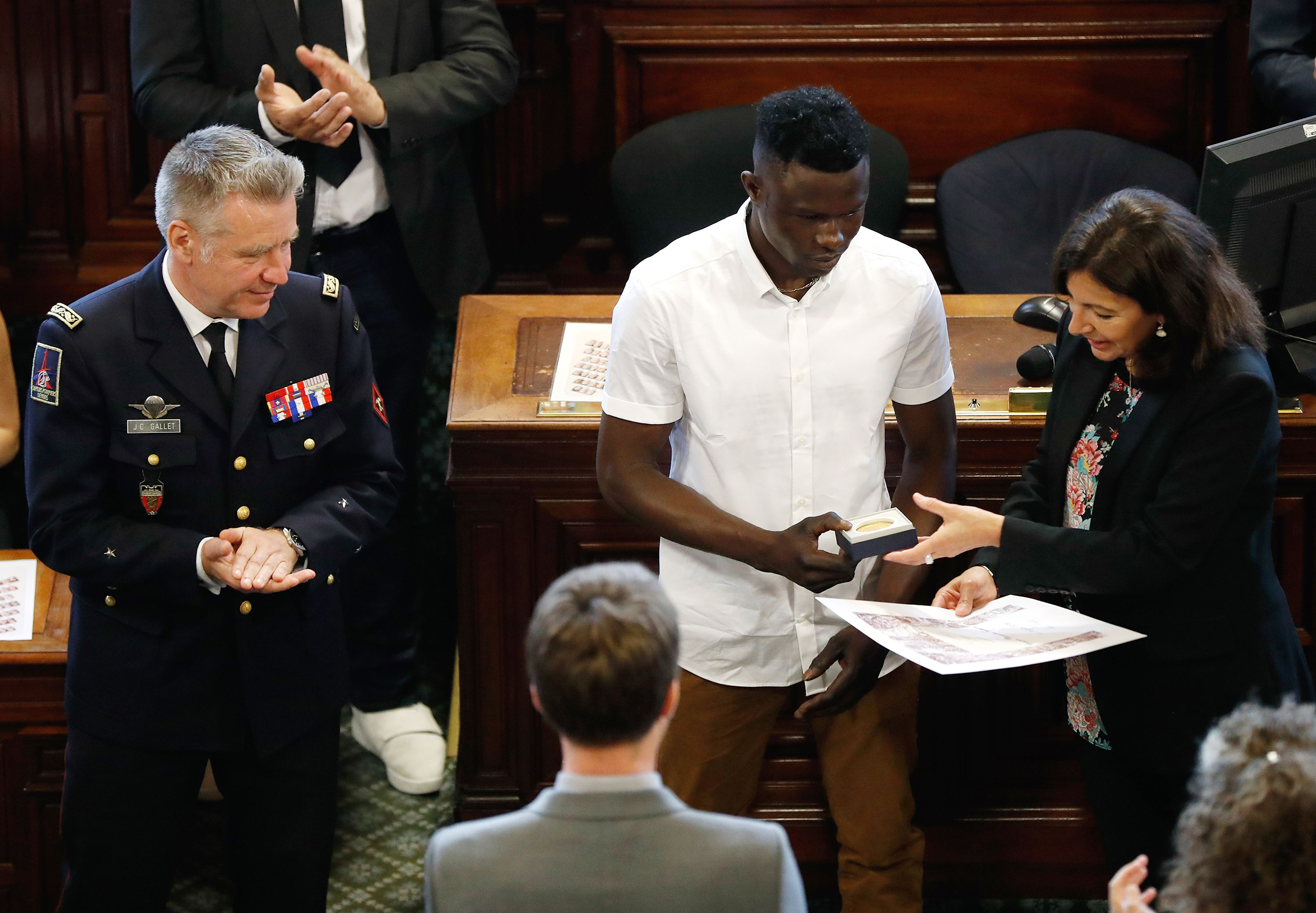 Mamoudou Gassama, center, is awarded with the city's Grand Vermeil medal by Paris' mayor Anne Hidalgo in Paris on June 4, 2018. (Francois Guillot—AFP/Getty Images)