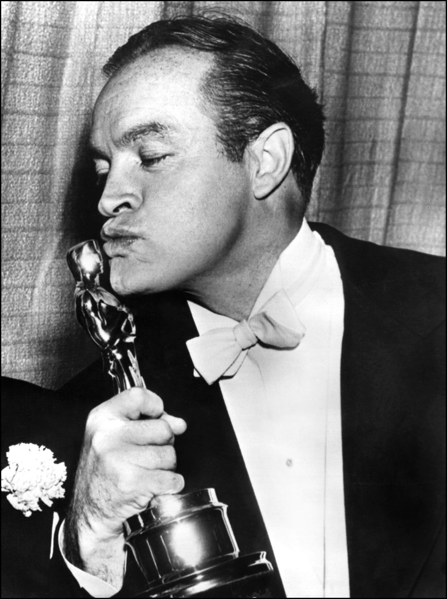 US entertainer Bob Hope shown in photo dated 20 March 1953 kissing the Oscar he received for Special Honors at the Academy Awards show in Hollywood. (Joe Rustan—AFP/Getty Images)