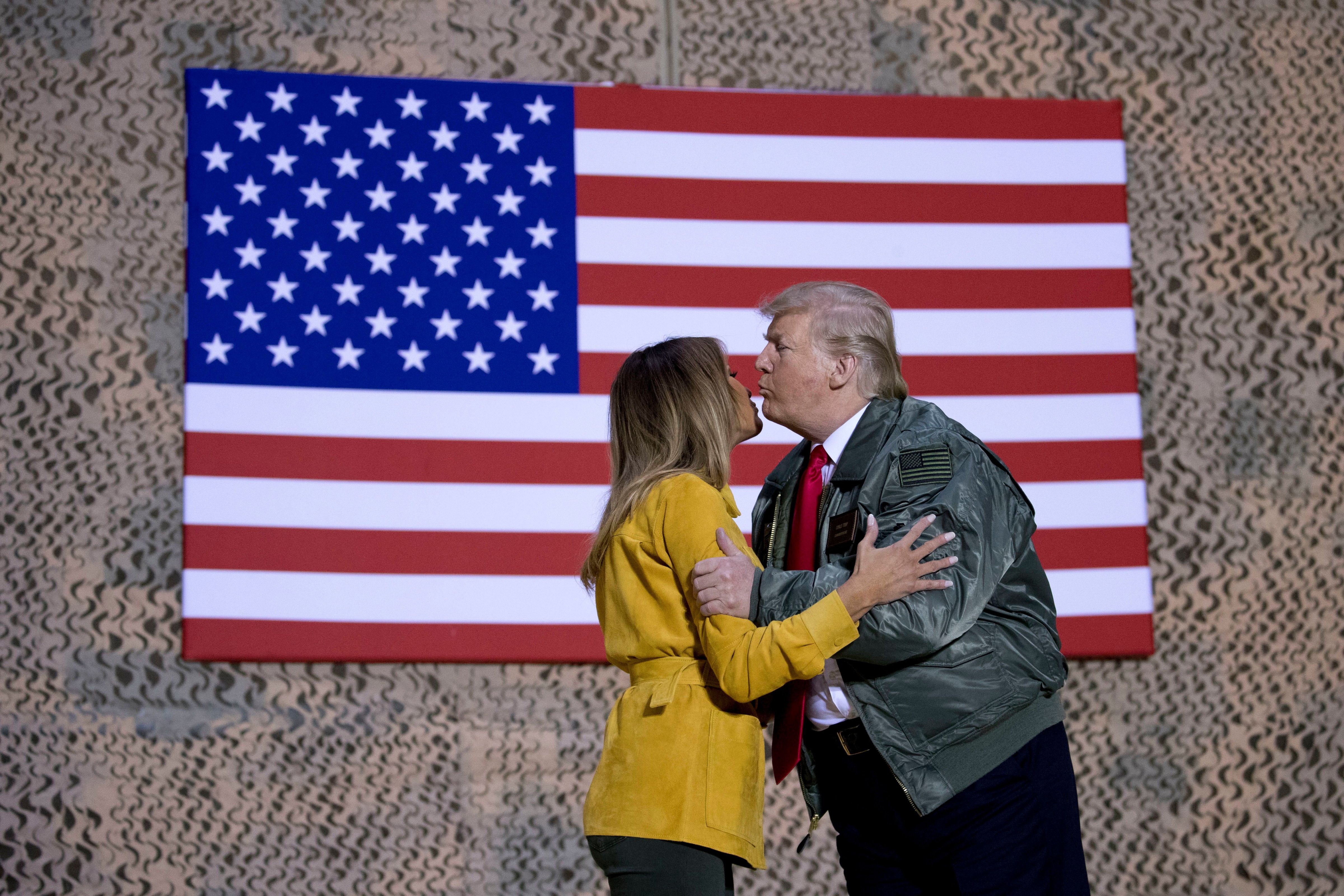 President Donald Trump kisses first lady Melania Trump during a hanger rally at Al Asad Air Base, Iraq, on Dec. 26, 2018. President Donald Trump, who is visiting Iraq, says he has 'no plans at all' to remove US troops from the country. (Andrew Harnik—AP/REX/Shutterstock)