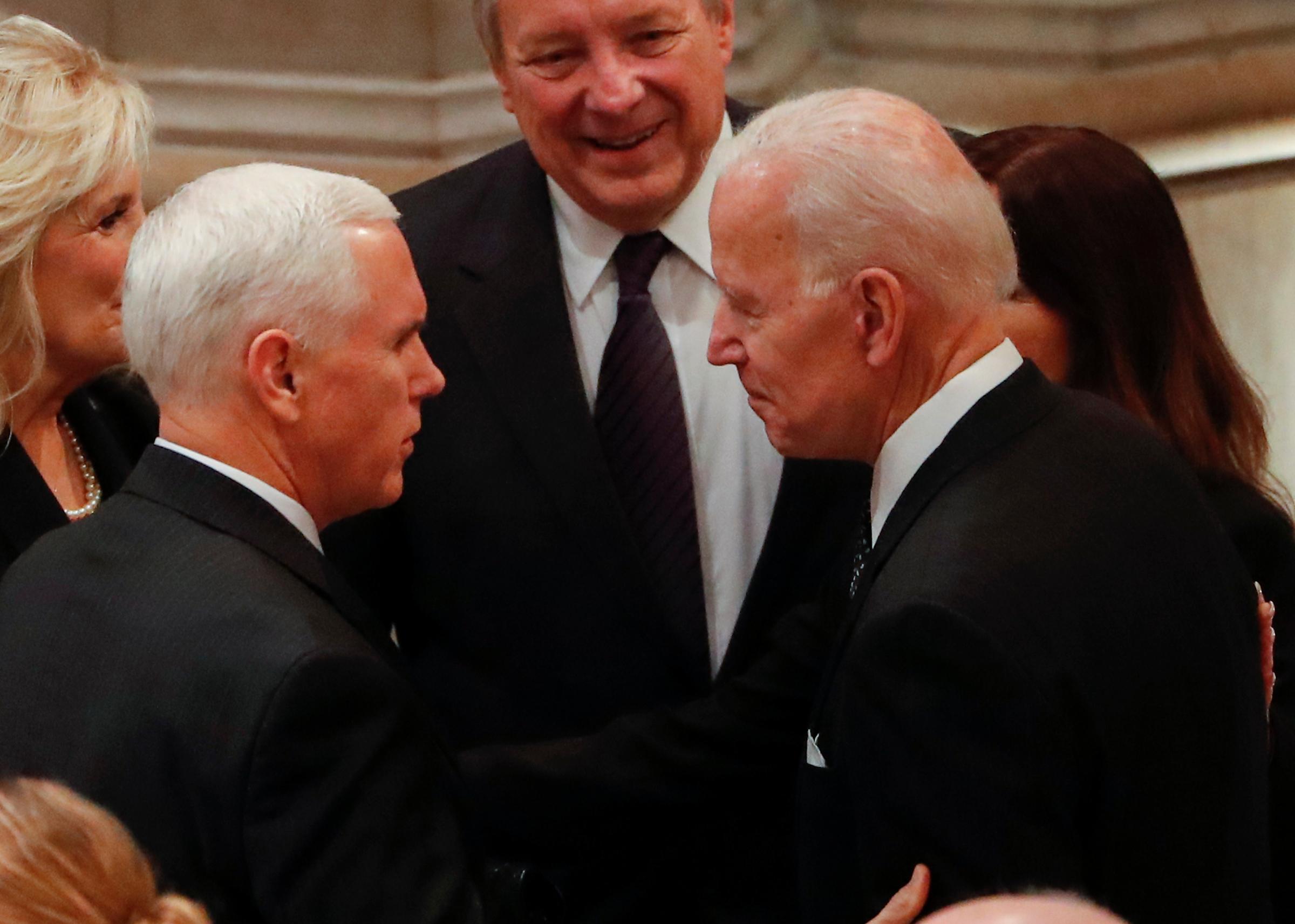 United States Vice President Mike Pence greets Former United States Vice President Joe Biden as they arrive for the funeral services for former United States President George H. W. Bush at the National Cathedral