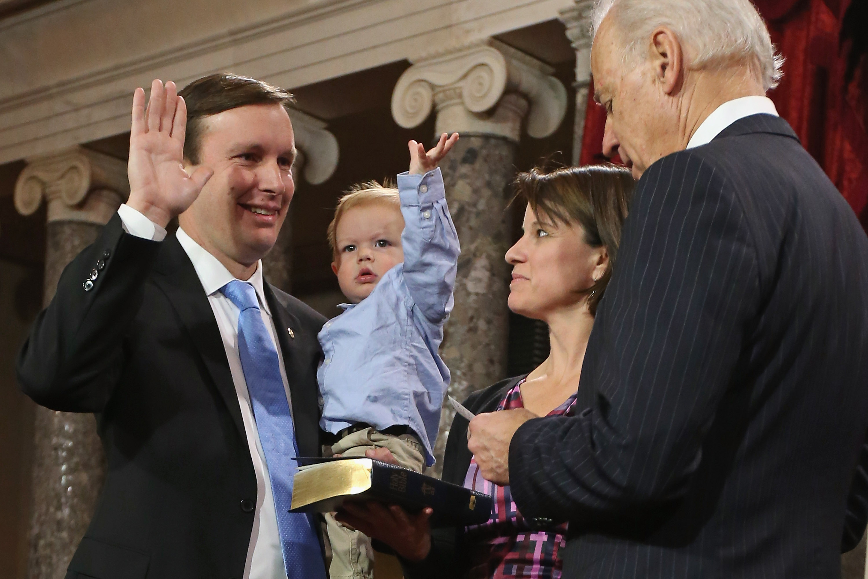 Rider Murphy raises his hand just like his father, U.S. Sen. Chris Murphy (D-CT) (L) as he participates in a reenacted swearing-in with his wife Catherine Murphy and U.S. Vice President Joe Biden in the Old Senate Chamber at the U.S. Capitol January 3, 2013 (Chip Somodevilla—Getty Images)