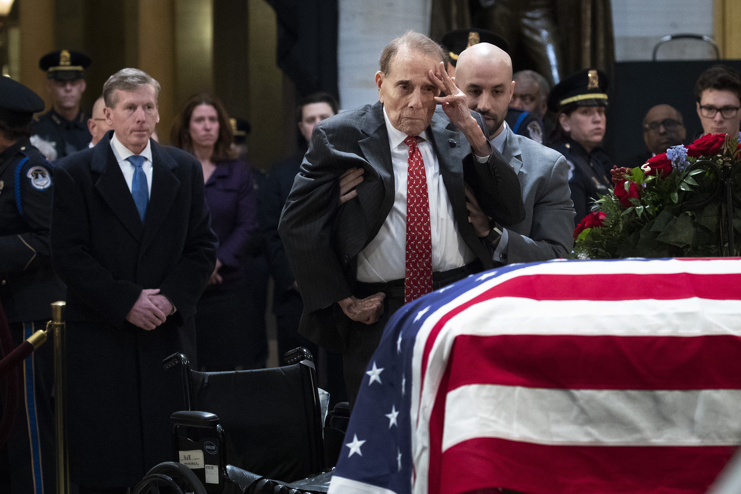 Former Senator Bob Dole stands up and salutes the casket of the late former President George H.W. Bush as he lies in state at the U.S. Capitol, on Dec. 4, 2018. (Drew Angerer—Getty Images)