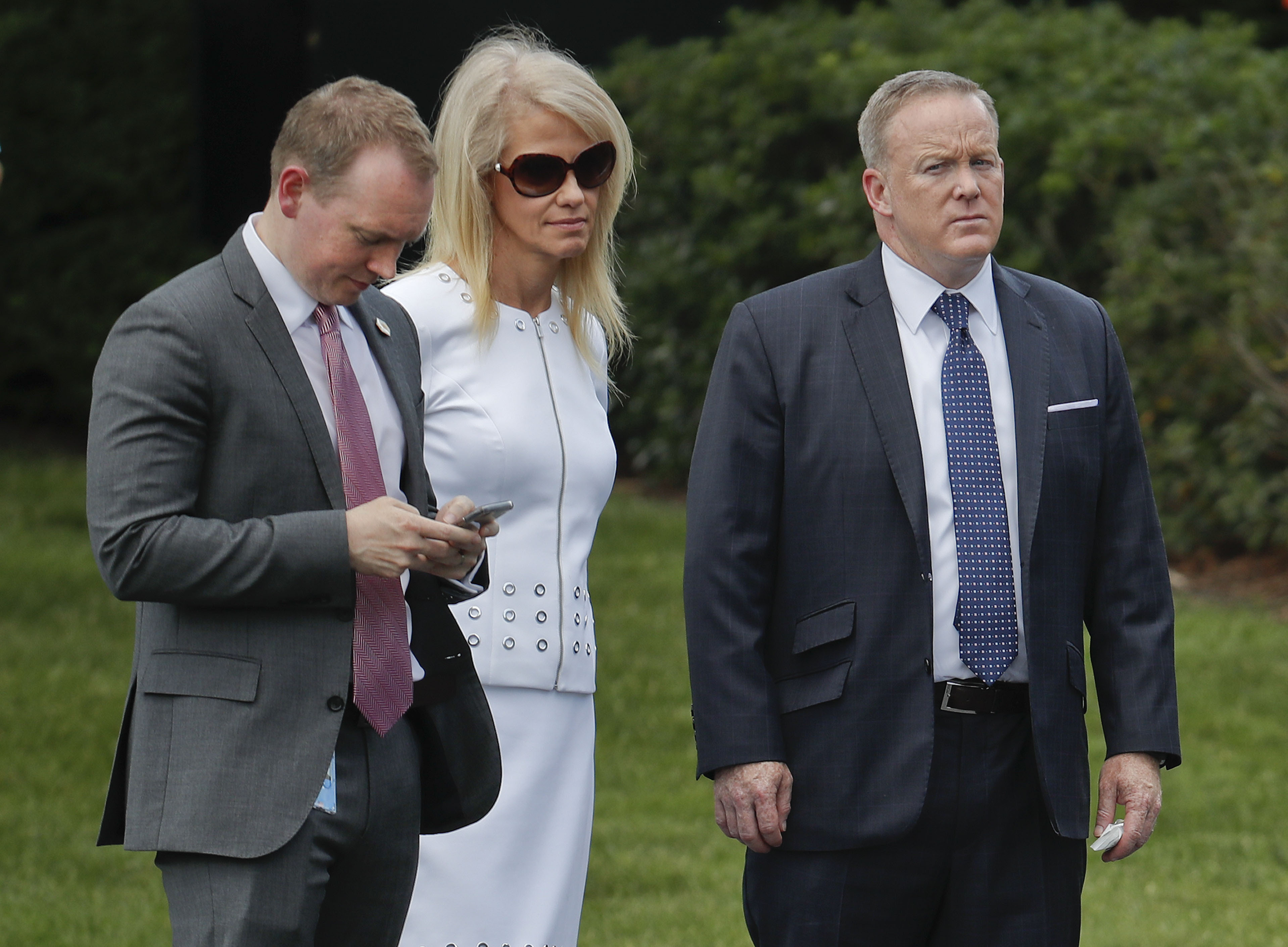 in this file photo, Cliff Sims, left, then-Director of White House Message Strategy, stands with Kellyanne Conway, center, senior adviser to President Donald Trump, and former White House Press Secretary Sean Spicer, right, as they listen to President Donald Trump during a ceremony on the South Lawn of the White House in Washington. Sims' new Trump tell-all, 'Team of Vipers,' digs into the people who surround the President. (Pablo Martinez Monsivais&mdash;AP)