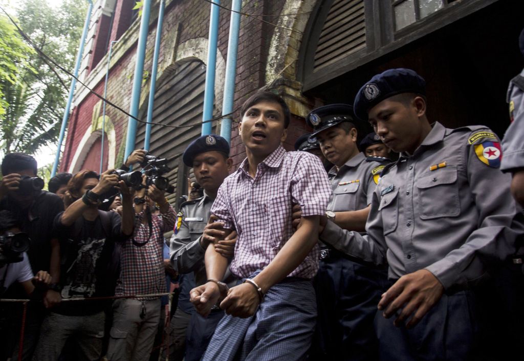 Detained Reuters journalist Kyaw Soe Oo  is escorted by police out of a court in Yangon, Myanmar on Aug. 27, 2018. (Aung Kyaw Htet—AFP/Getty Images)