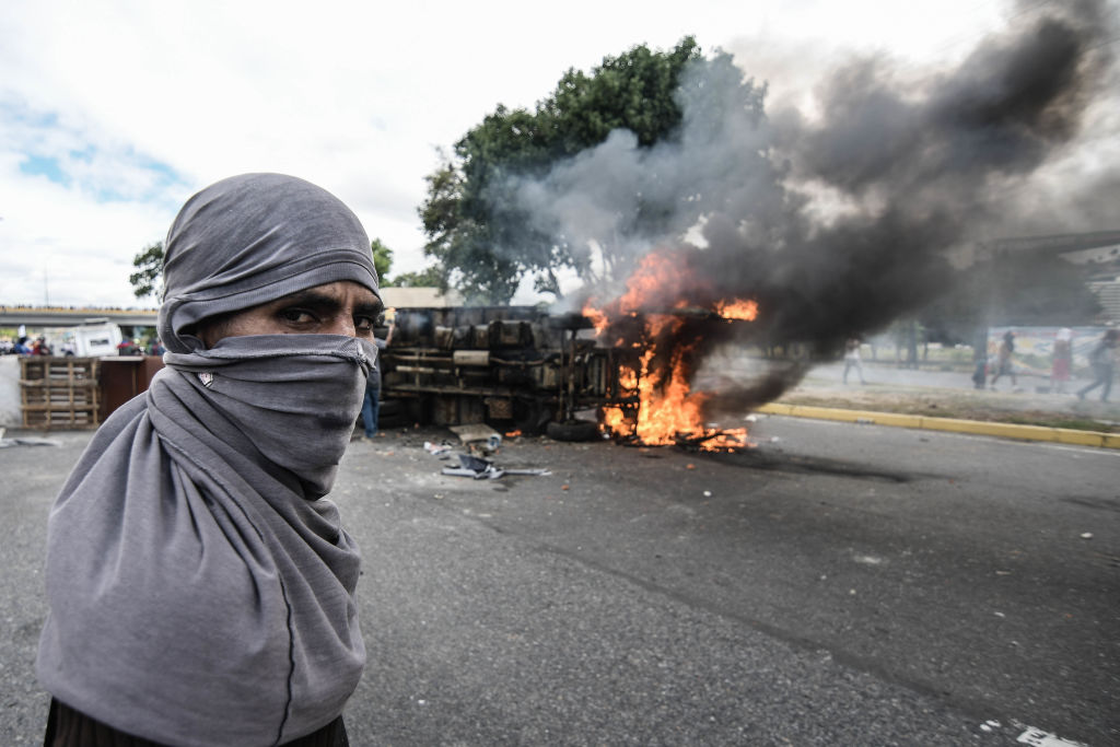 A protester stands near burning barricades during a demonstration against Nicolas Maduro in Caracas on Jan. 23, 2019. (SOPA Images&mdash;LightRocket/Getty Images)