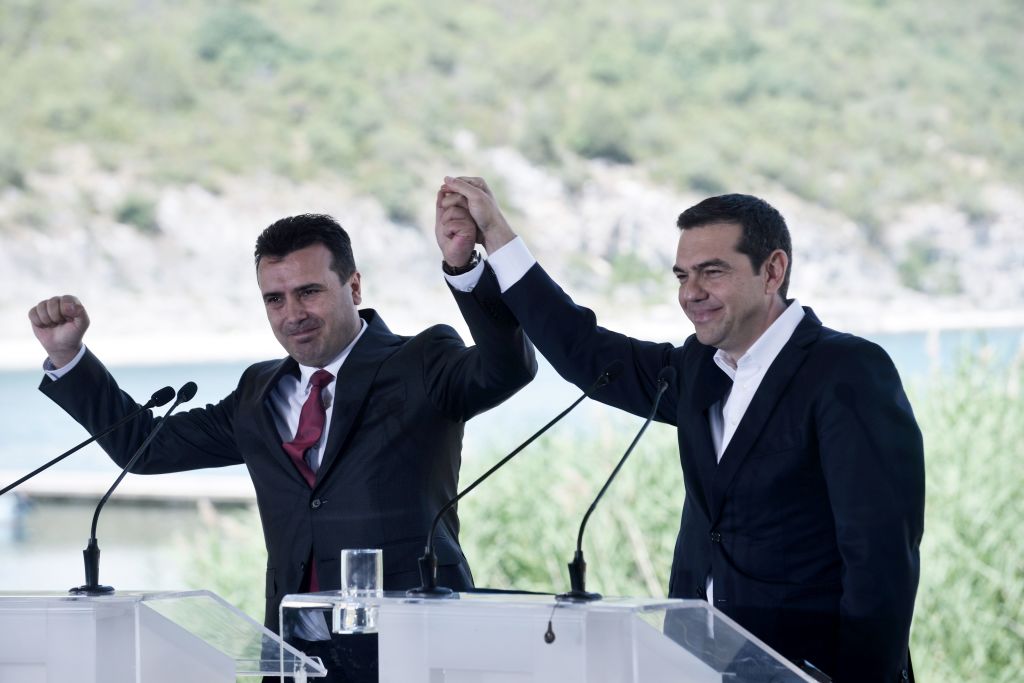 Greek Prime Minister Alexis Tsipras (R) and Macedonian Prime Minister Zoran Zaev raise their hands during a signing ceremony between officials from Greece and Macedonia at Prespes Lake on June 17, 2018. (Sakis Mitrolidis—AFP/Getty Images)