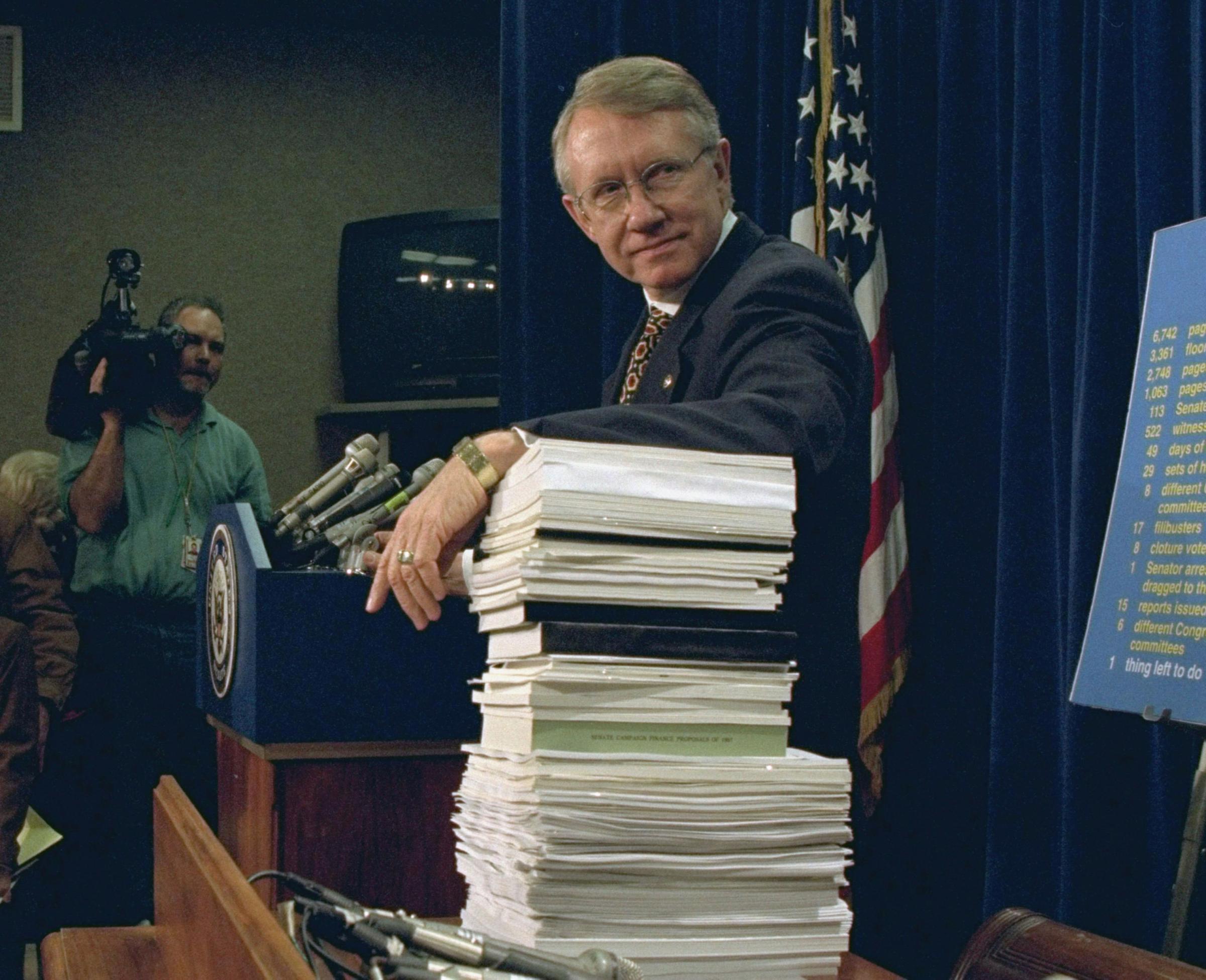 Sen. Harry Reid leans on a stack of documents pertaining to campaign finance reform