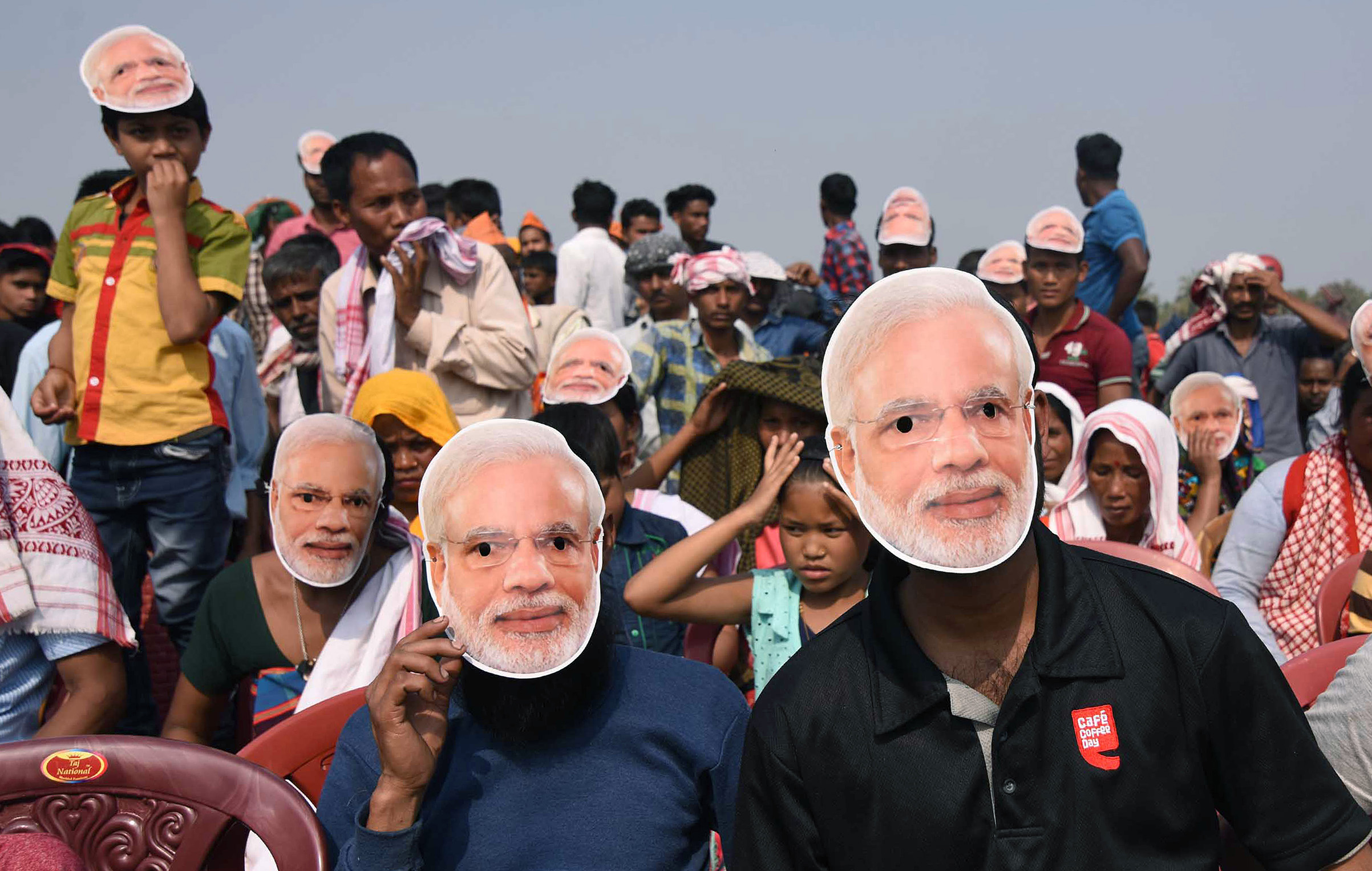 Supporters of the Bharatiya Janata Party (BJP) wearing masks of Indian Prime Minister Narendra Modi listen to Modi during an election rally at Phulbari in west Garo hills of Meghalaya on Feb 22, 2018. (Biju Boro—AFP/Getty Images)
