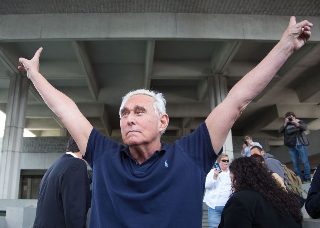 Roger Stone throws up peace signs outside court