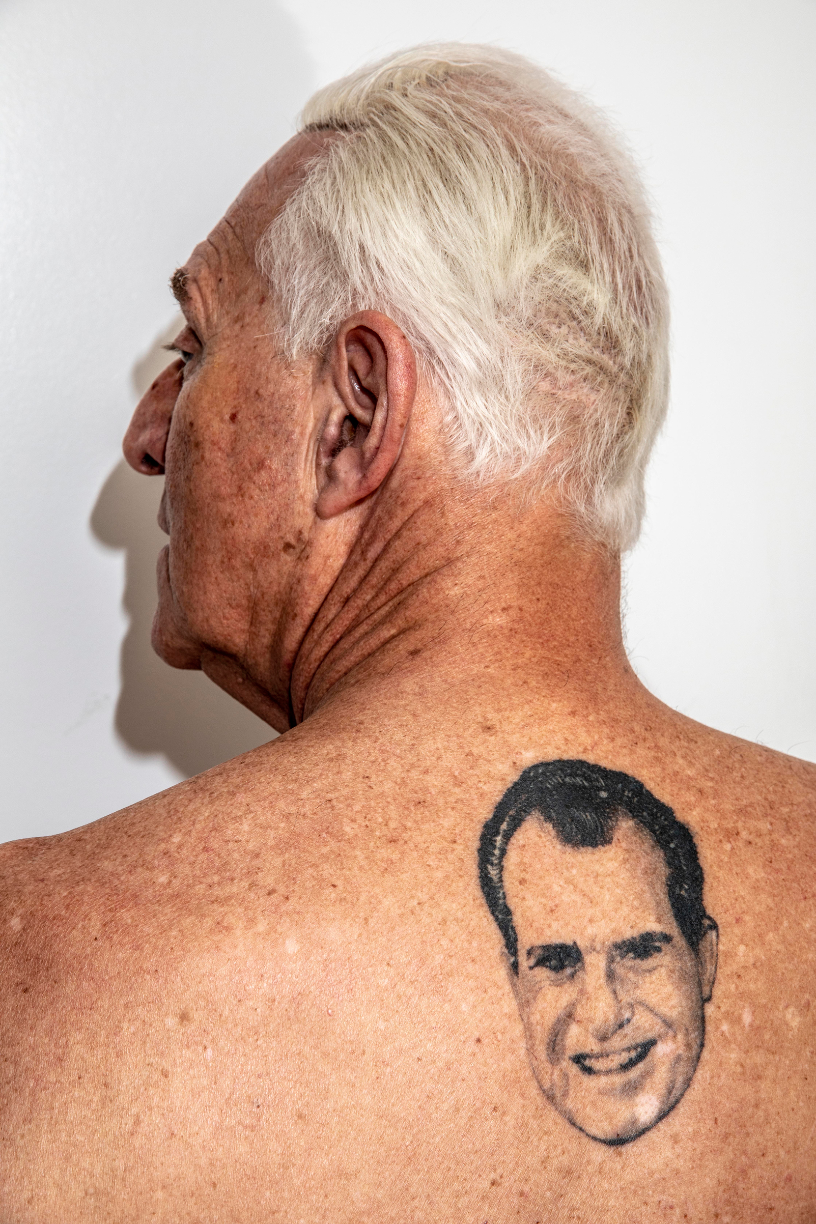 Stone shows off his Richard Nixon tattoo at his apartment i​n New York in June 2018. (Mark Peterson—Redux Pictures)