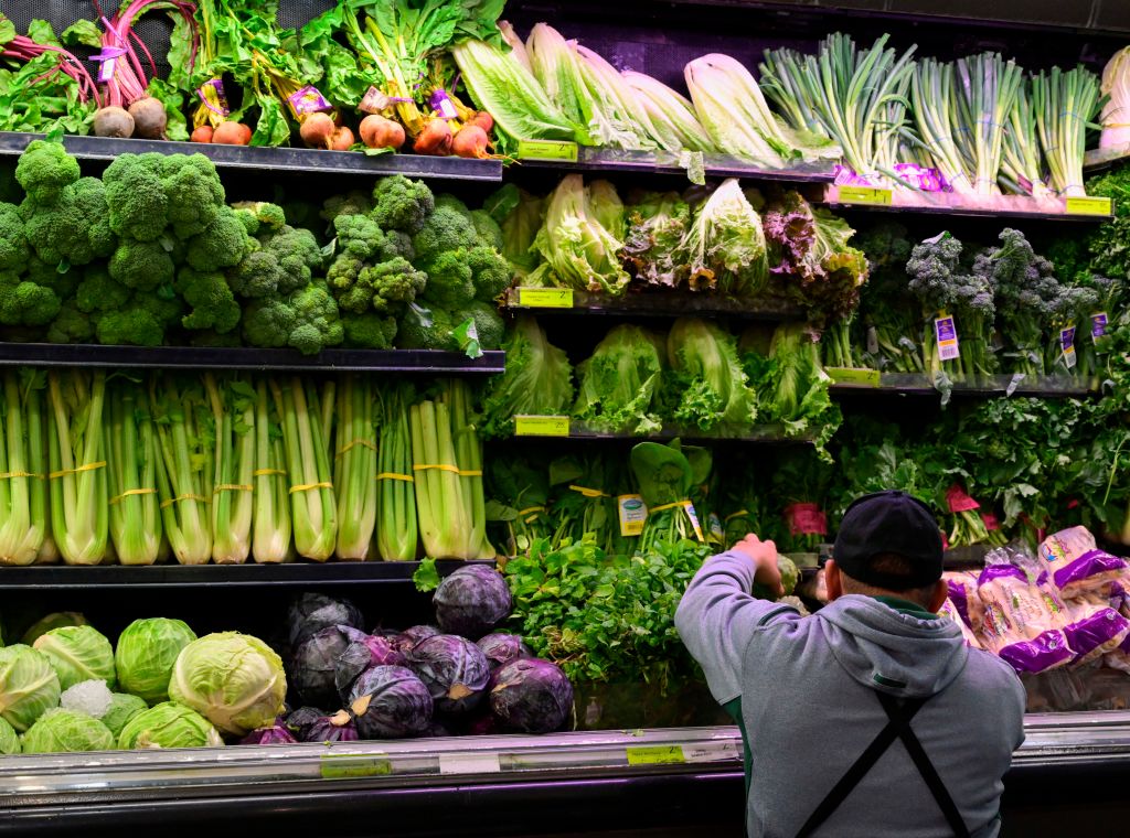 A produce worker stocks shelves near romaine lettuce (top shelf center) at a supermarket in Washington, DC on November 20, 2018. - US health officials warned consumers not to eat any romaine lettuce and to throw away any they might have in their homes, citing an outbreak of E. coli poisoning. The Centers for Disease Control and Prevention (CDC) issued the warning against all Romaine lettuce just two days before the Thanksgiving holiday, when American families gather and feast together. (Photo by Andrew CABALLERO-REYNOLDS / AFP)        (Photo credit should read ANDREW CABALLERO-REYNOLDS/AFP/Getty Images) (A produce worker stocks shelves near romaine lettuce (top shelf center) at a supermarket in Washington, DC on November 20, 2018.)