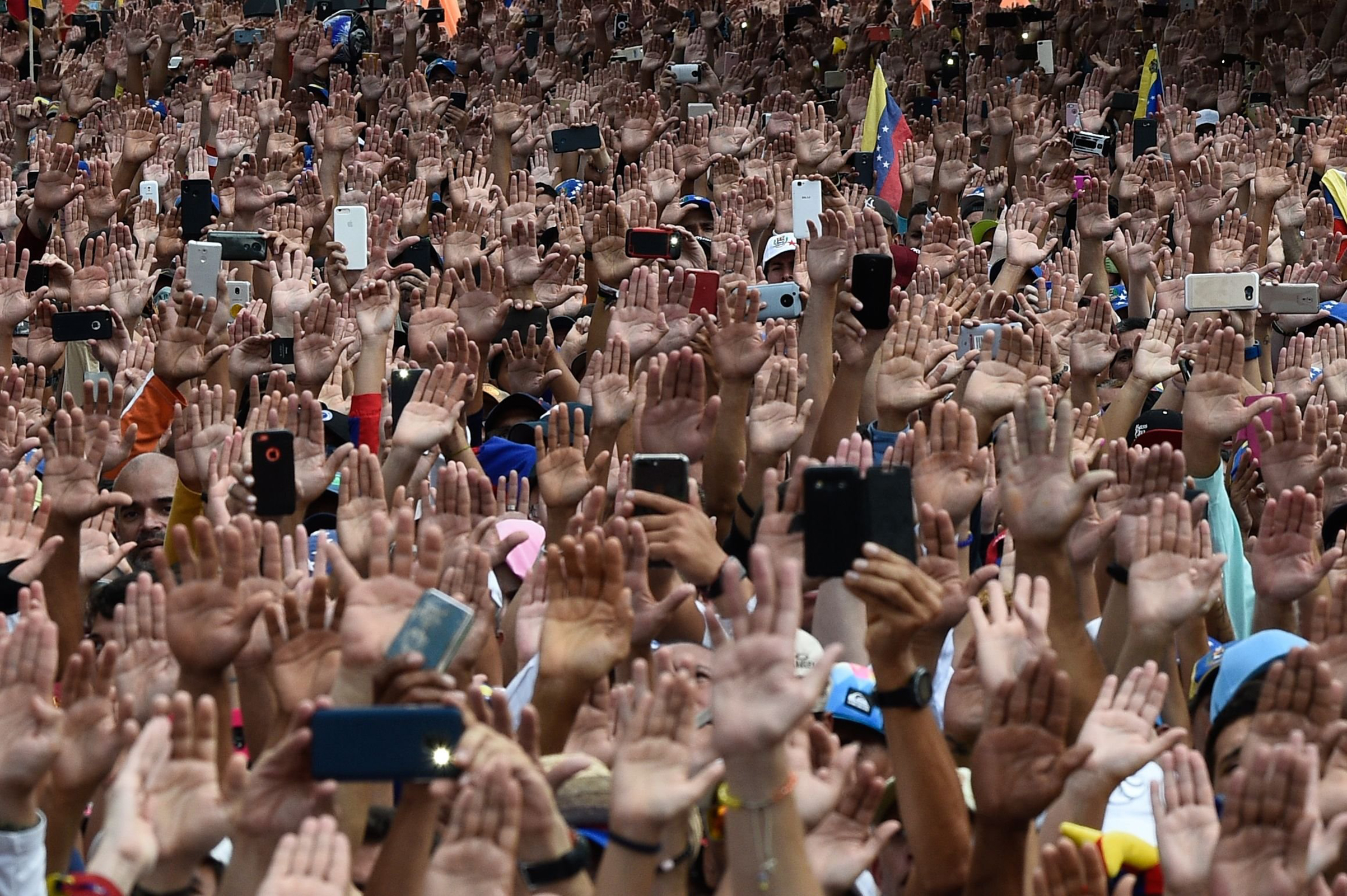 People raise their hands during a massive anti-government rally against Venezuelan President Nicolás Maduro in Caracas on Jan. 23, 2019. (Federico Parra—AFP/Getty Images)