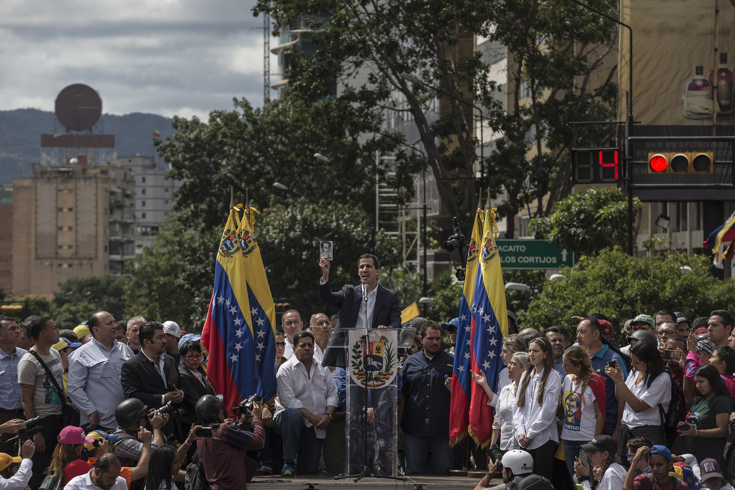 Juan Guaido, leader of the opposition-controlled congress, shows the National Constitution as he declares himself interim president in front of hundreds of Venezuelans during a mass rally against Nicolás Maduro in Caracas on Jan. 23, 2019. (Marcelo Perez Del Carpio—Anadolu Agency/Getty Images)