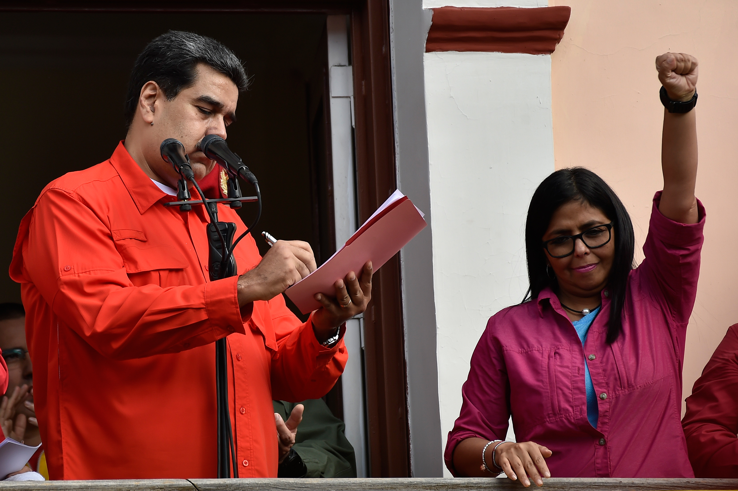 Venezuela's President Nicolás Maduro, next to Vice President Delcy Rodríguez, signs a document breaking off diplomatic ties with the U.S. at a balcony at the Miraflores Presidential Palace in Caracas on Jan. 23, 2019. (Luis Robayo—AFP/Getty Images)