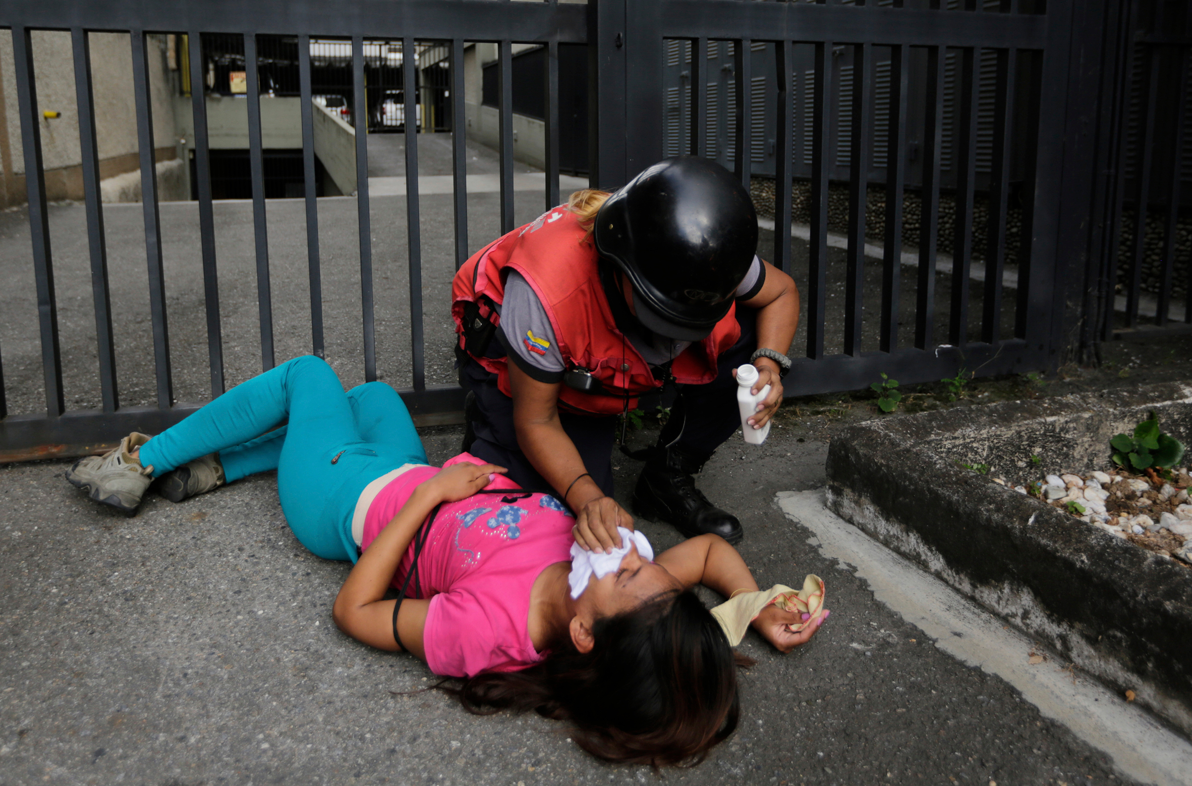 An anti-government protester overcome by tear gas is aided by a paramedic during clashes after a rally demanding the resignation of President Nicolas Maduro in Caracas on Jan. 23, 2019. (Fernando Llano—AP)