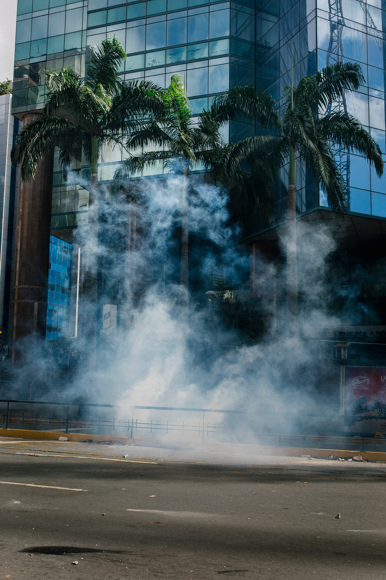 Tear gas floats over the pavement during a protest in El Rosal in Caracas on Jan. 23, 2019. (Andrea Hernandez)
