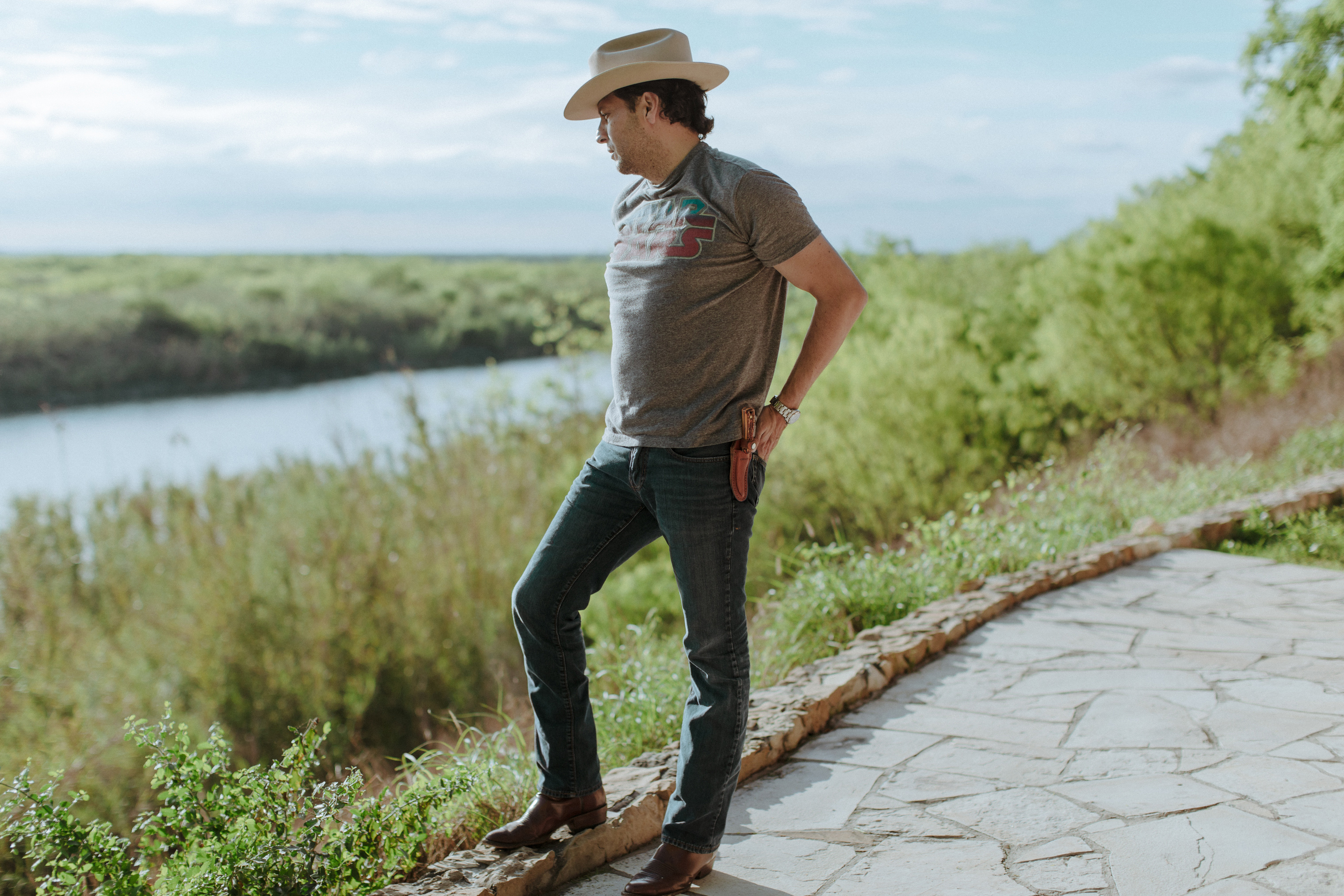 Texas State Representative Alfonso "Poncho" Nevárez, stands at the Rio Grande River, in his backyard, Eagle Pass, Texas. (Elliot Ross)