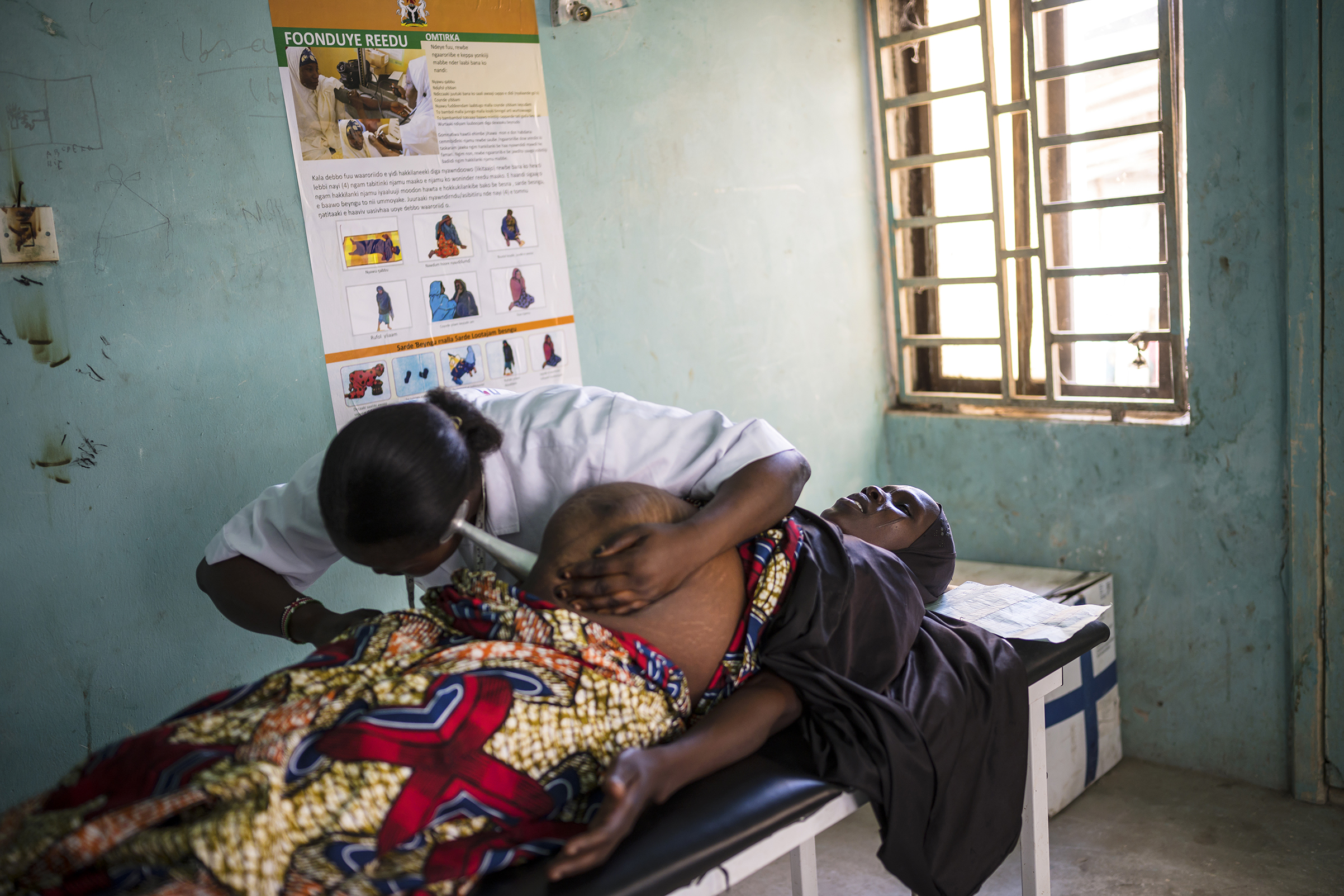 Midwife Topchin Job Goro, 28, checks Maryam Mohammed, 30, who is 38 weeks pregnant with her 8th child in the Ngala clinic (Lynsey Addario for TIME)