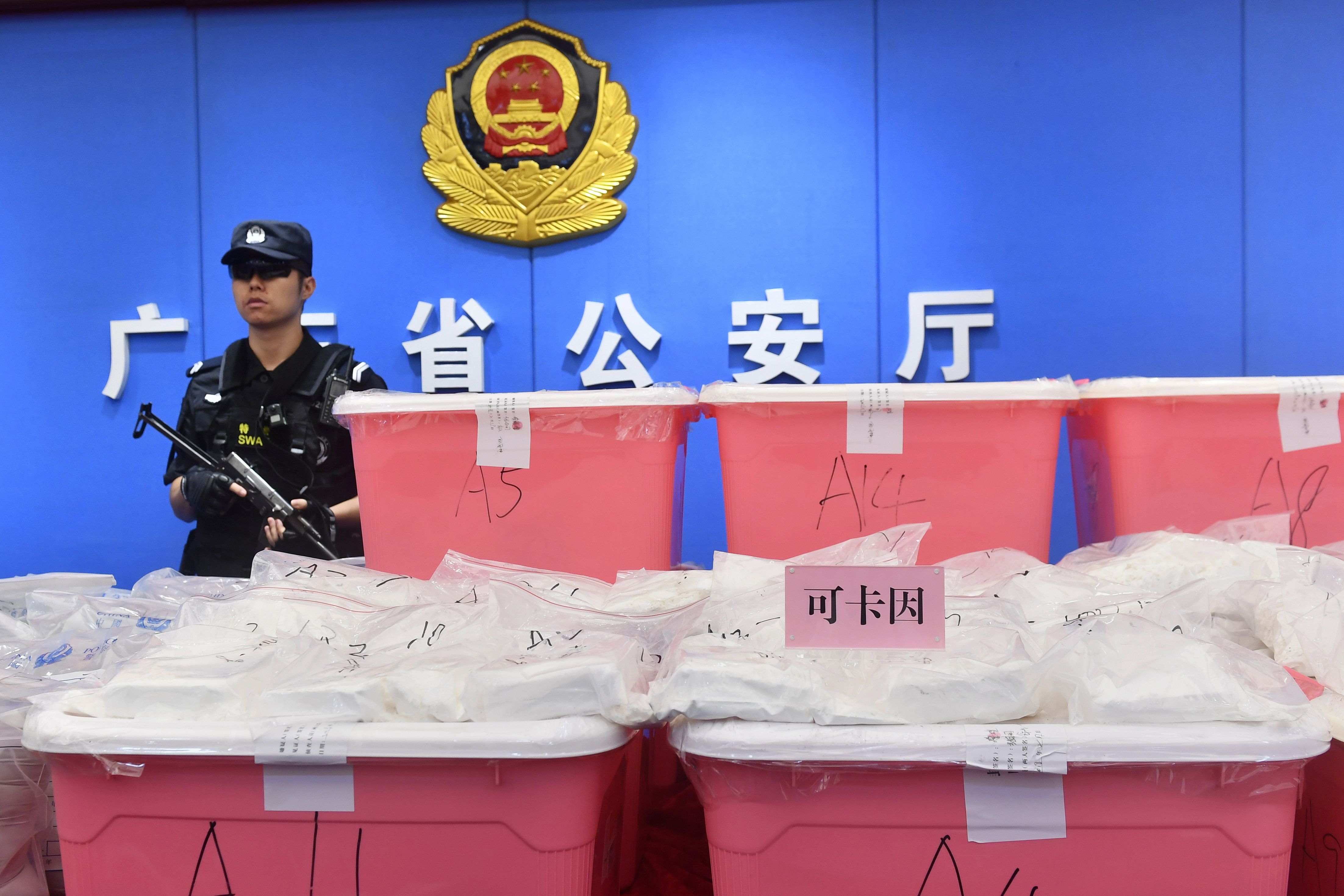 A policeman stands guard next to bags of cocaine seized in Guangzhou in China's southern Guangdong province on April 24, 2018. (-&mdash;AFP/Getty Images)