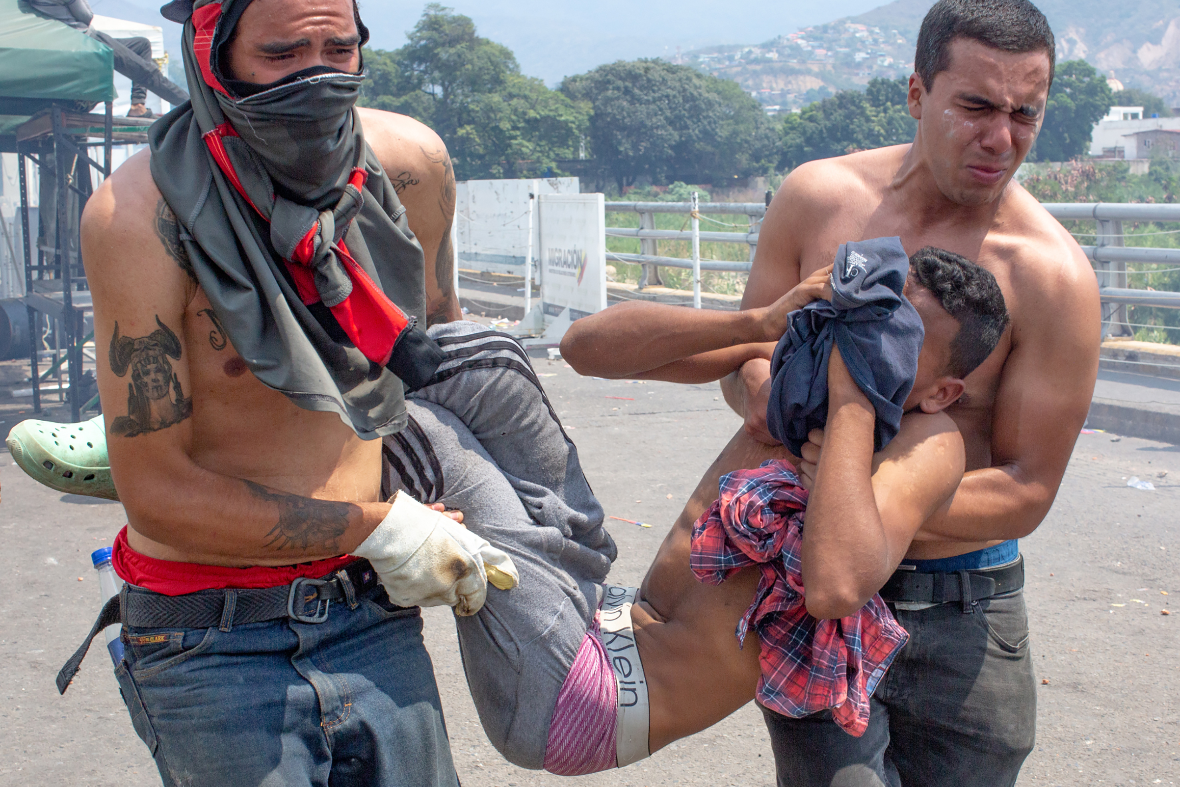 An injured demonstrator is carried away toward the Colombian end of the bridge. (Photograph by TIME)