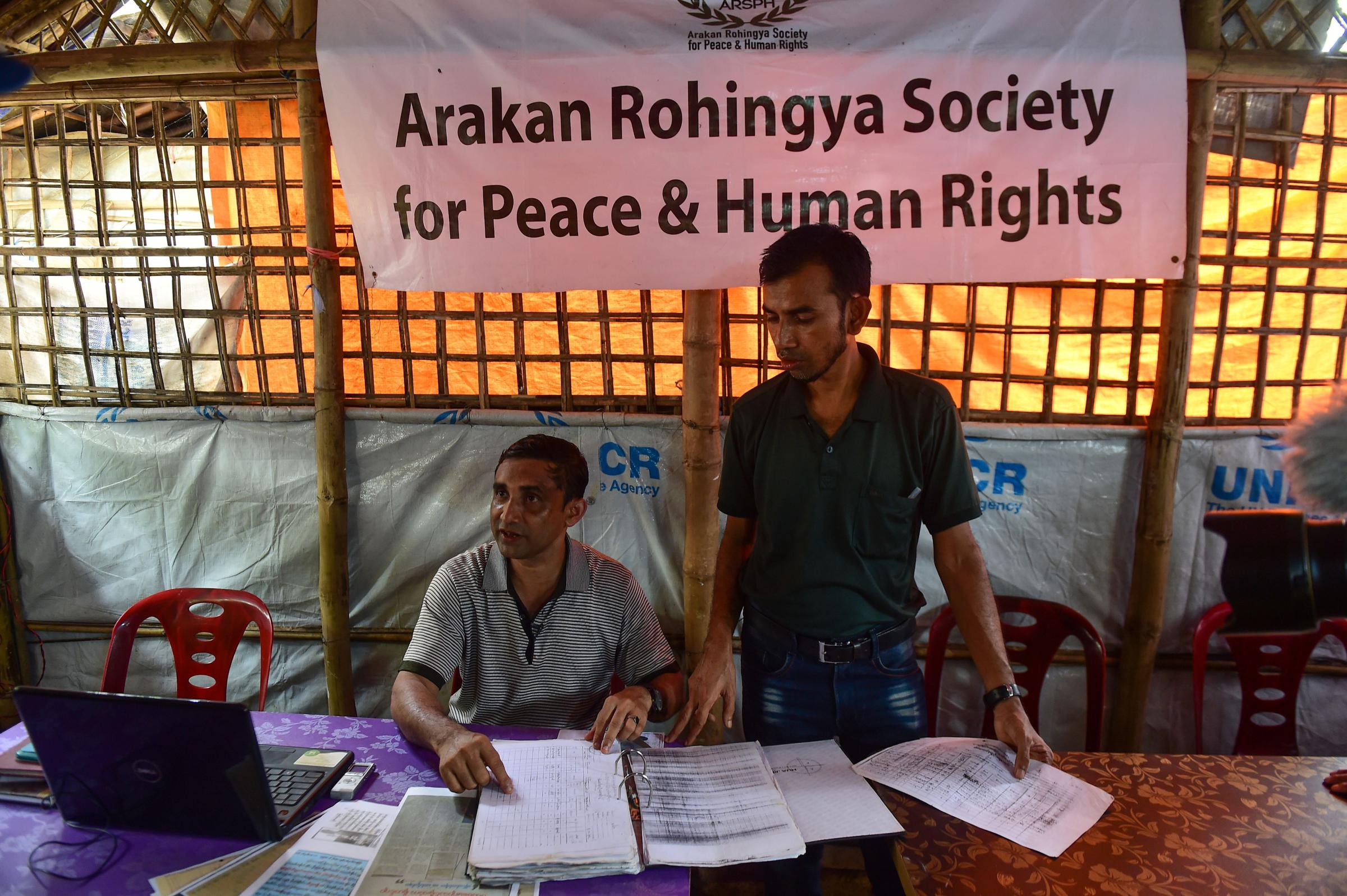 Mohibullah, a Rohingya refugee activist, and a volunteer with data collected from Rohingya refugees of alleged abuses by Myanmar soldiers