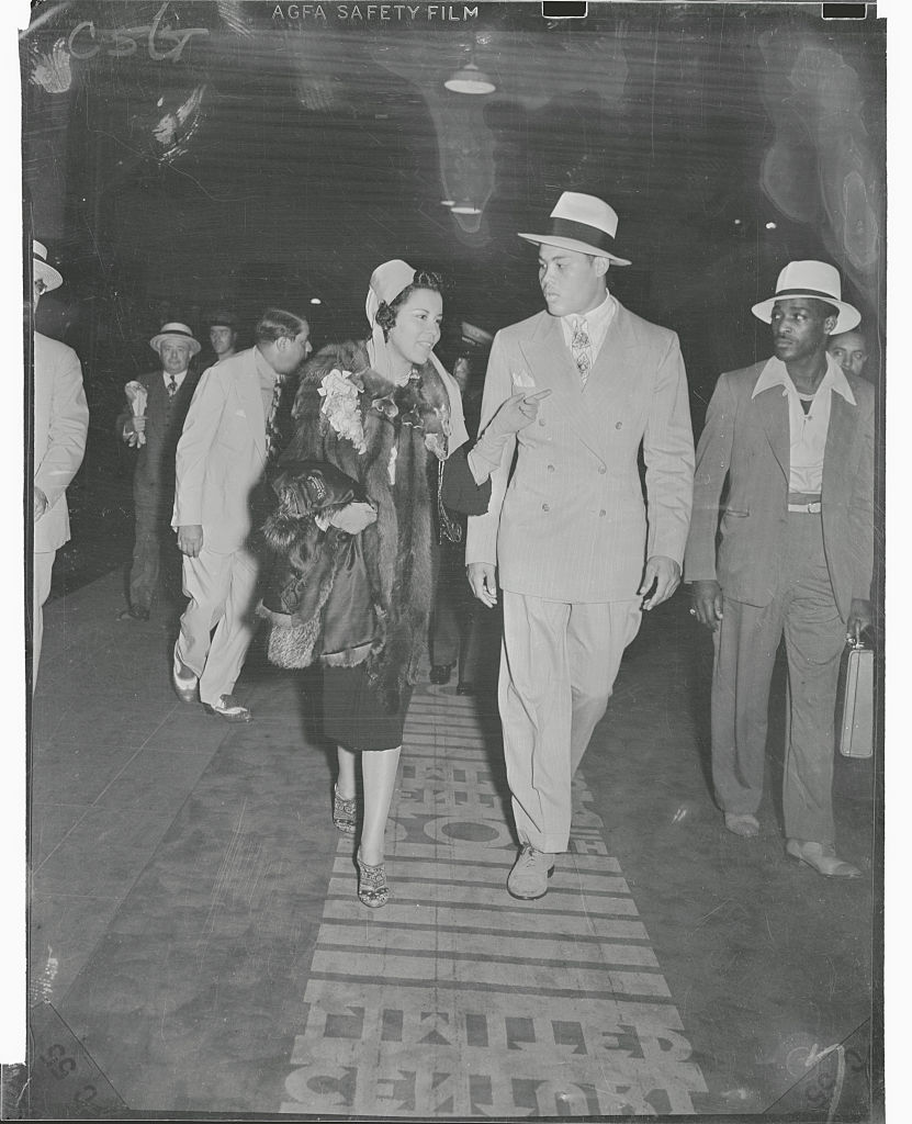 Joe Louis and his wife as they walk down to the Twentieth Century Limited in the Grand Central Station to depart for Chicago the day after Louis' one round victory over Max Schmeling in Yankee Stadium, circa 1930s. (Bettmann—Bettmann Archive)