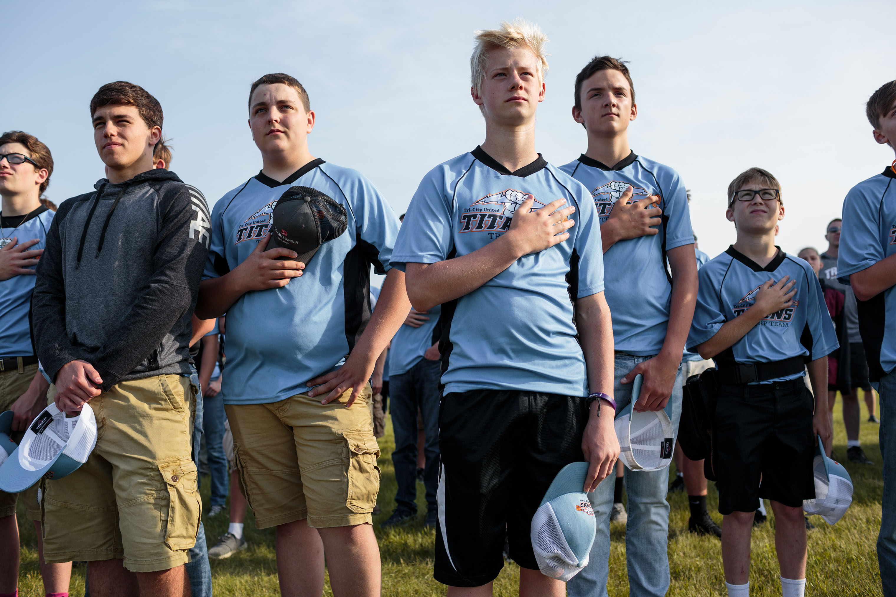 Students from Tri-City United High School stand for the Pledge of Allegiance early in the morning on June 15, 2018, before beginning to compete in the annual trap shooting championship in Alexandria, Minnesota. (Sarah Blesener for TIME)