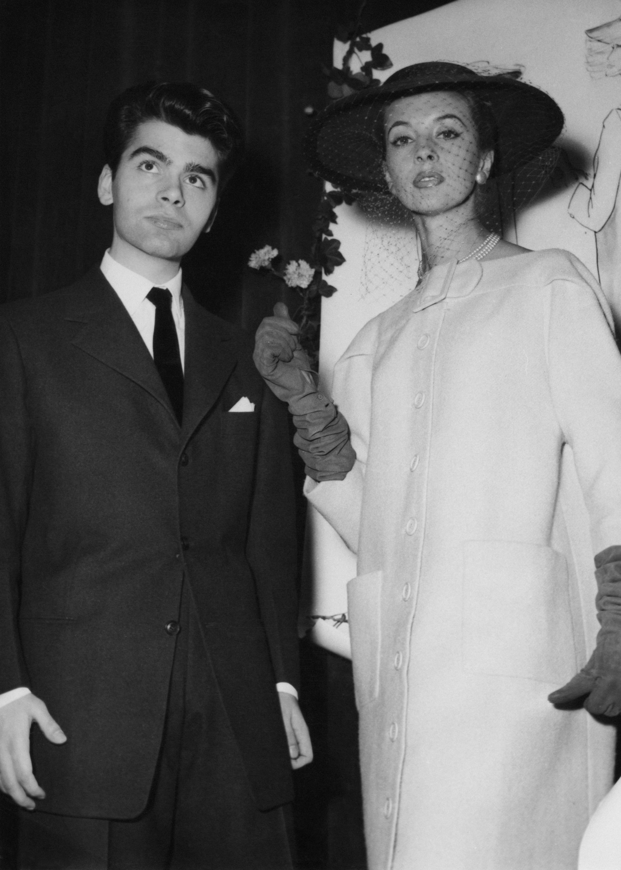 Karl Lagerfeld after winning the coats category in a design competition sponsored by the International Wool Secretariat in Paris on Dec. 14, 1954. With him is a model wearing his design. (Keystone/Hulton Archive/Getty Images)