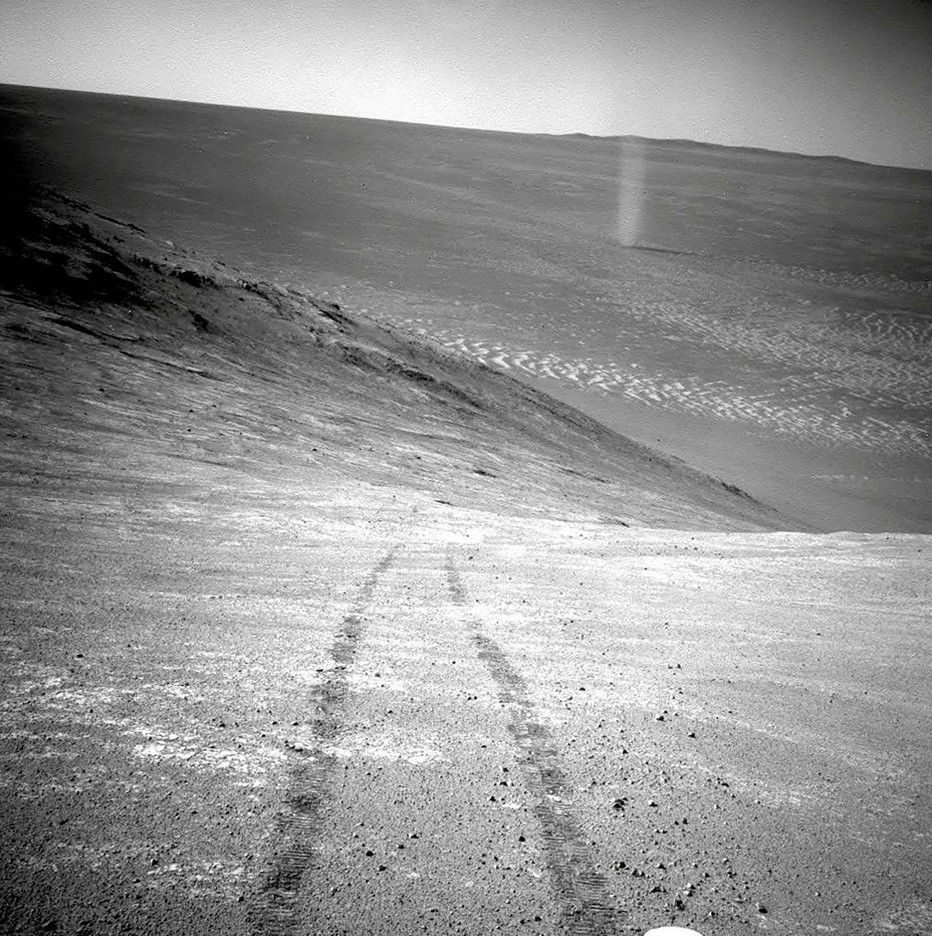 This photograph made available by NASA in March 2016 shows a dust devil in a valley on Mars, seen by the Opportunity rover perched on a ridge. The view looks back at the rover's tracks leading up the north-facing slope of "Knudsen Ridge." (AP/Shutterstock)