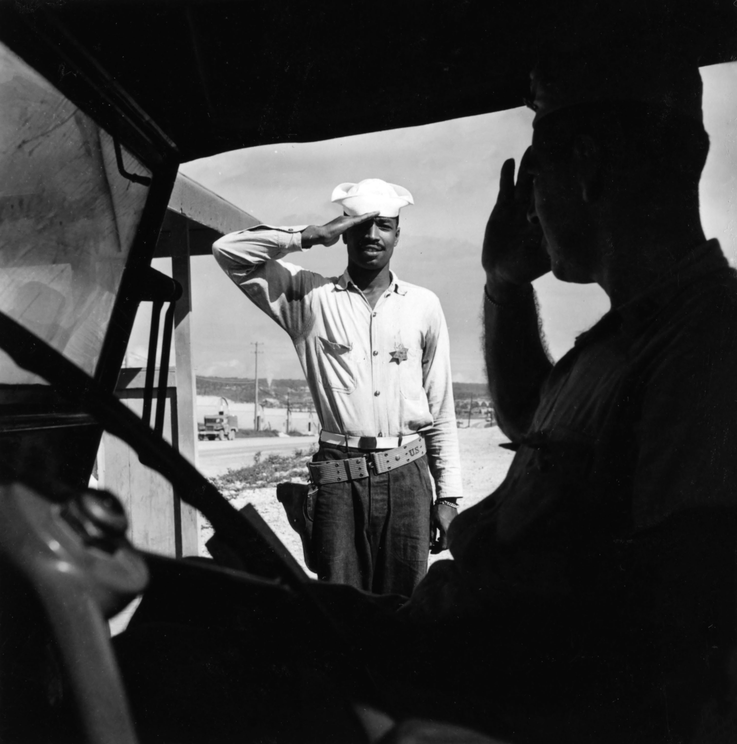 A sailor assigned to work as a laborer at the U.S. Naval Supply Depot on Guam saluting an officer. (Wayne Miller—Magnum Photos)