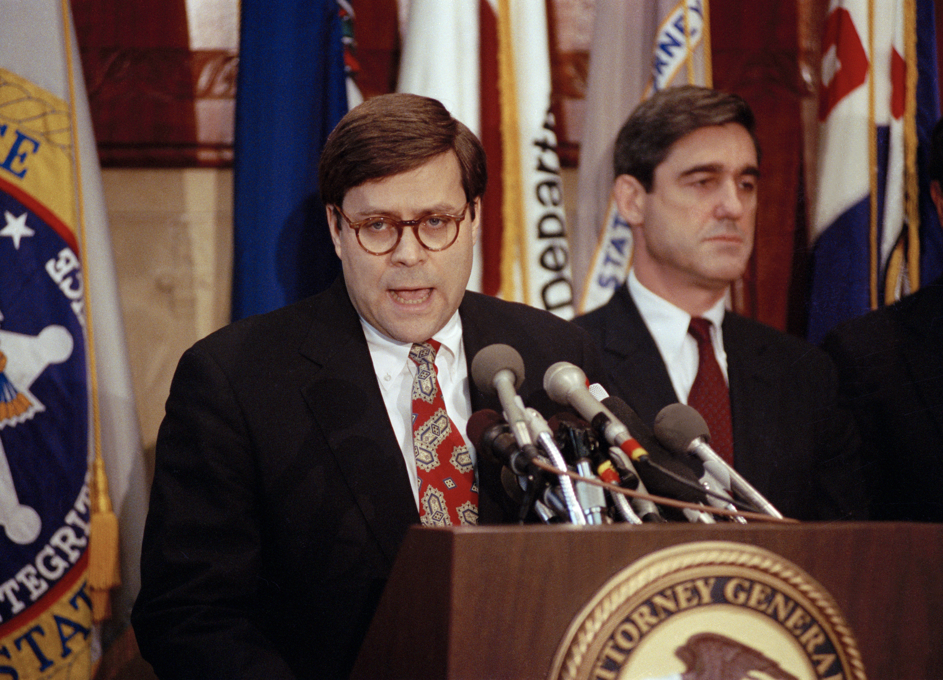 Attorney General William P. Barr speaks with reporters at a news conference in Washington, D.C., on Dec. 19, 1991. Assistant Attorney General Robert Mueller stands on his right. (Barry Thumma—AP)