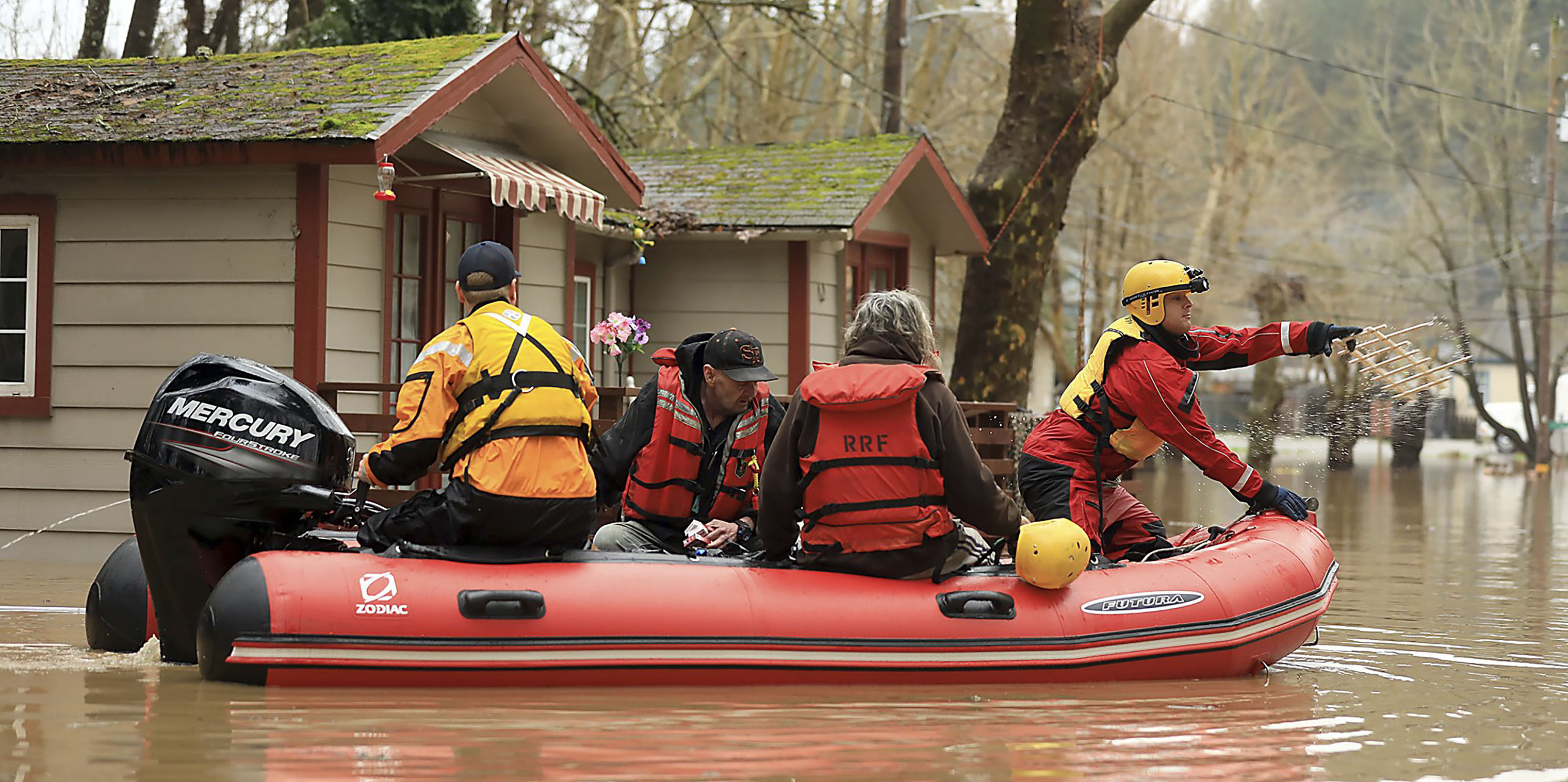 Ryan Lance, front, and Anthony Nash of the Russian River Fire Protection District swift water rescue team help residents of Sycamore Court Apartment Wednesday, Feb. 27, 2019, in lower Guerneville, California. (Kent Porter—AP)