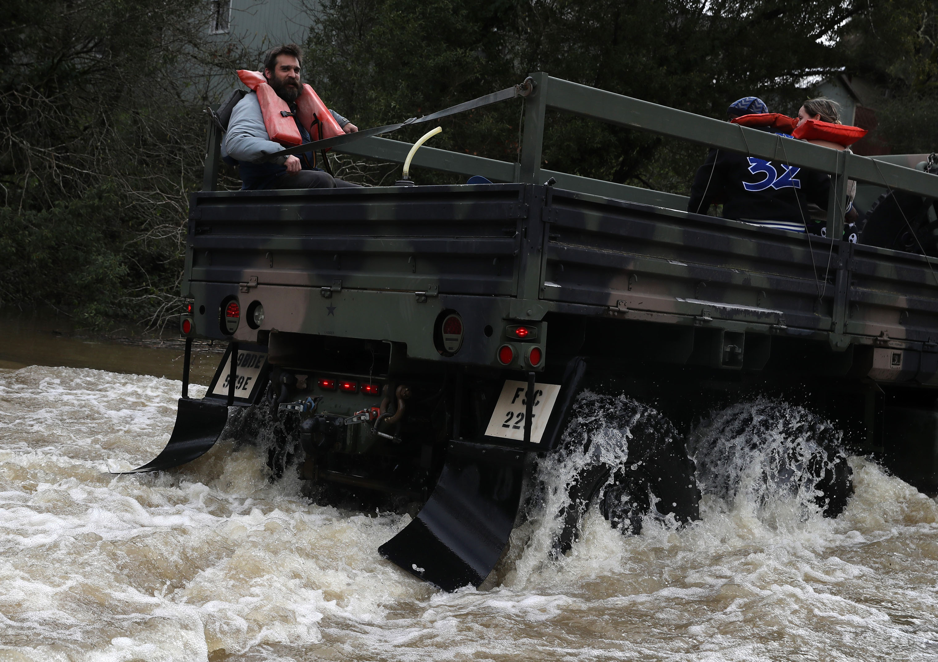Rescue workers evacuate residents on a truck as they drive through a flooded neighborhood on Feb. 27, 2019 in Forestville, California. (Justin Sullivan—Getty Images)