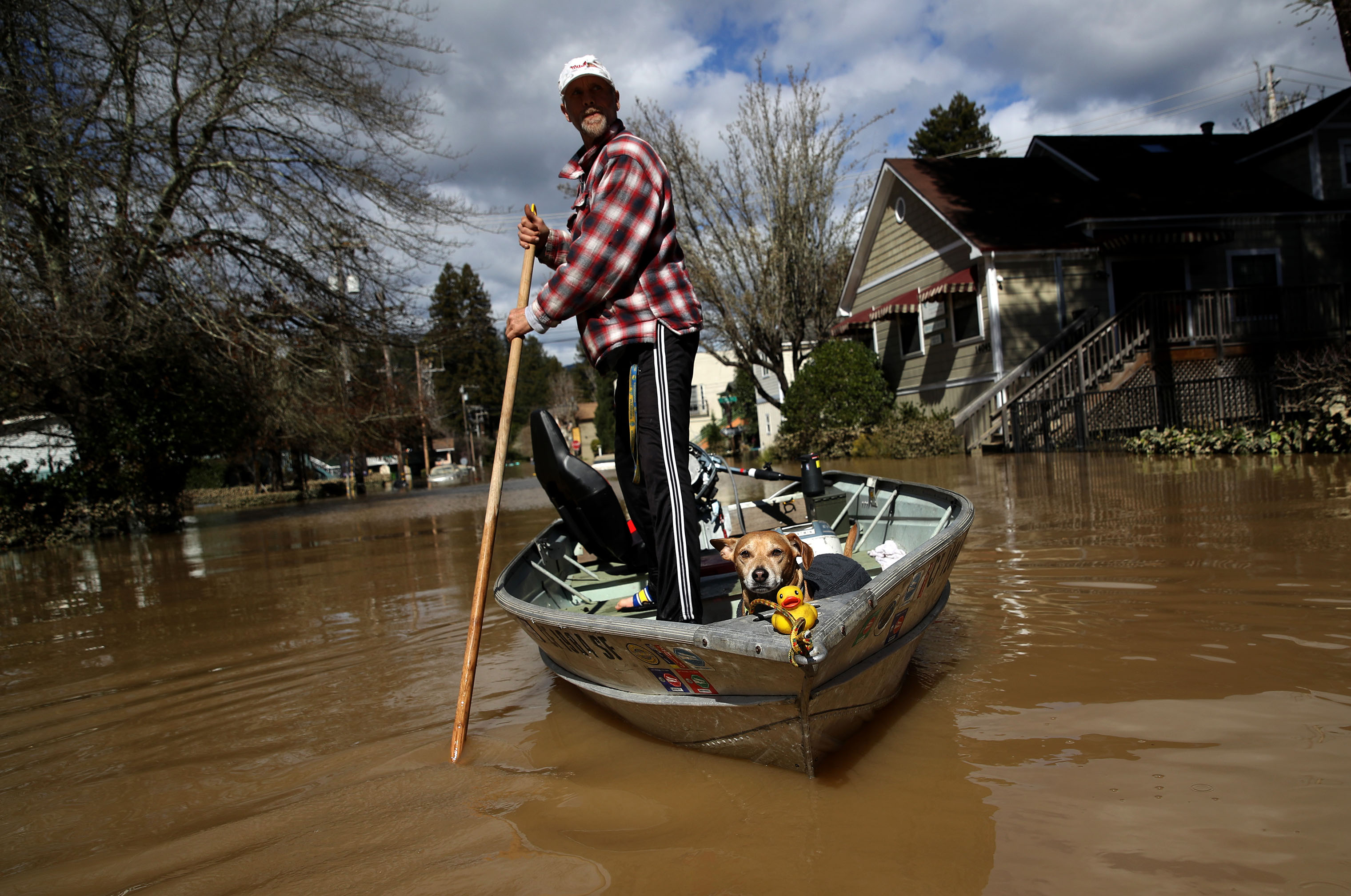 A resident and his dog navigate through a flooded neighborhood on Feb. 28, 2019 in Guerneville, California. (Justin Sullivan—Getty Images)