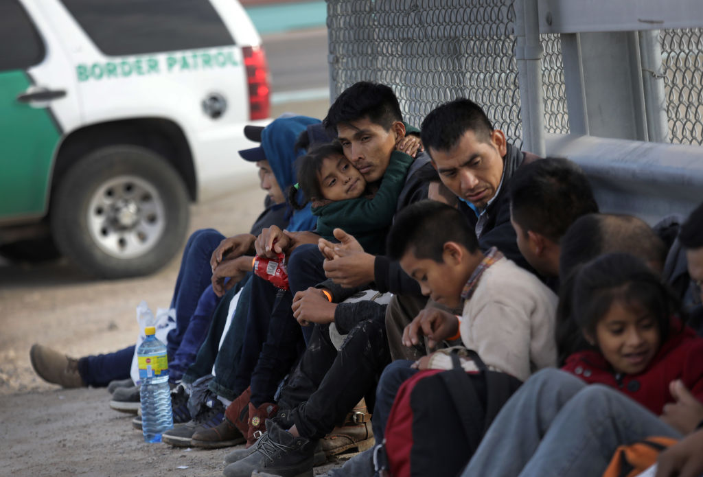 Central American migrants wait to be taken into custody and turning themselves in for political asylum after crossing into the United States