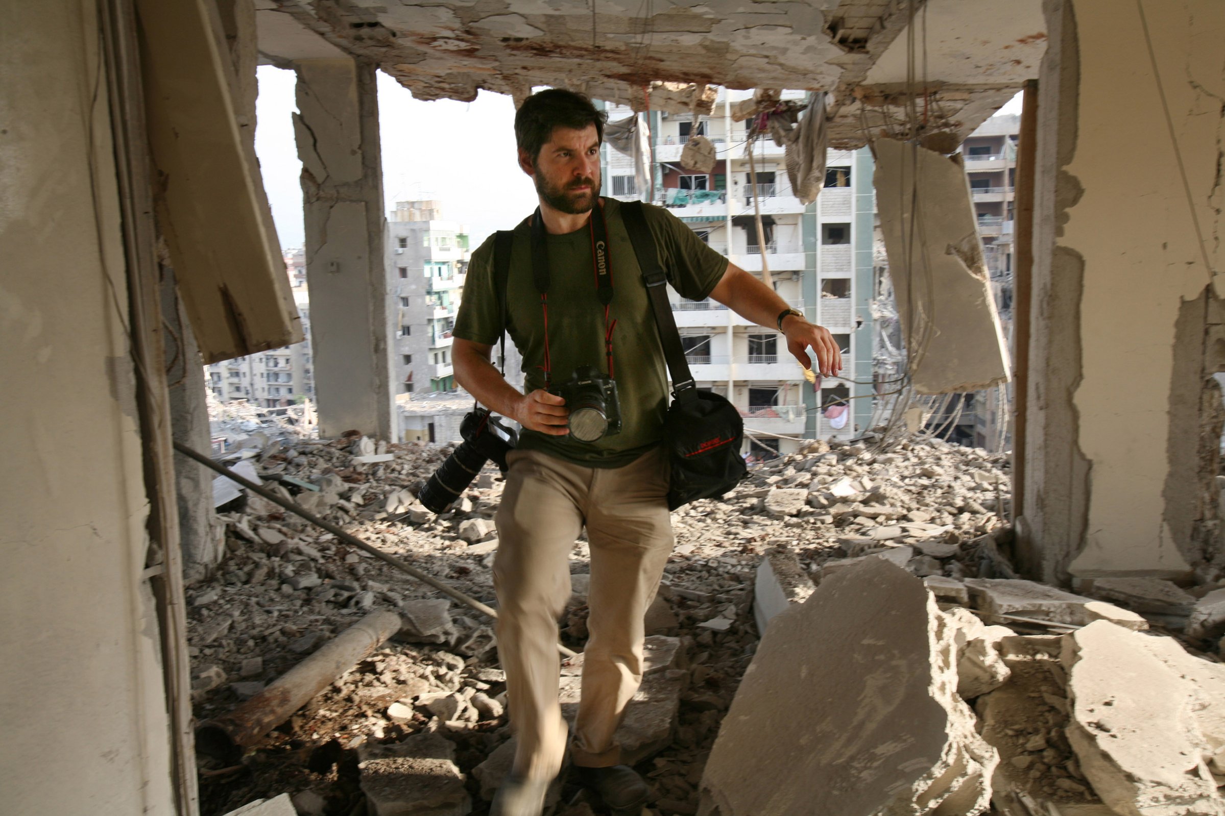 Getty Images photographer Chris Hondros walks through the ruins of a building in southern Beirut on Aug. 21, 2006.