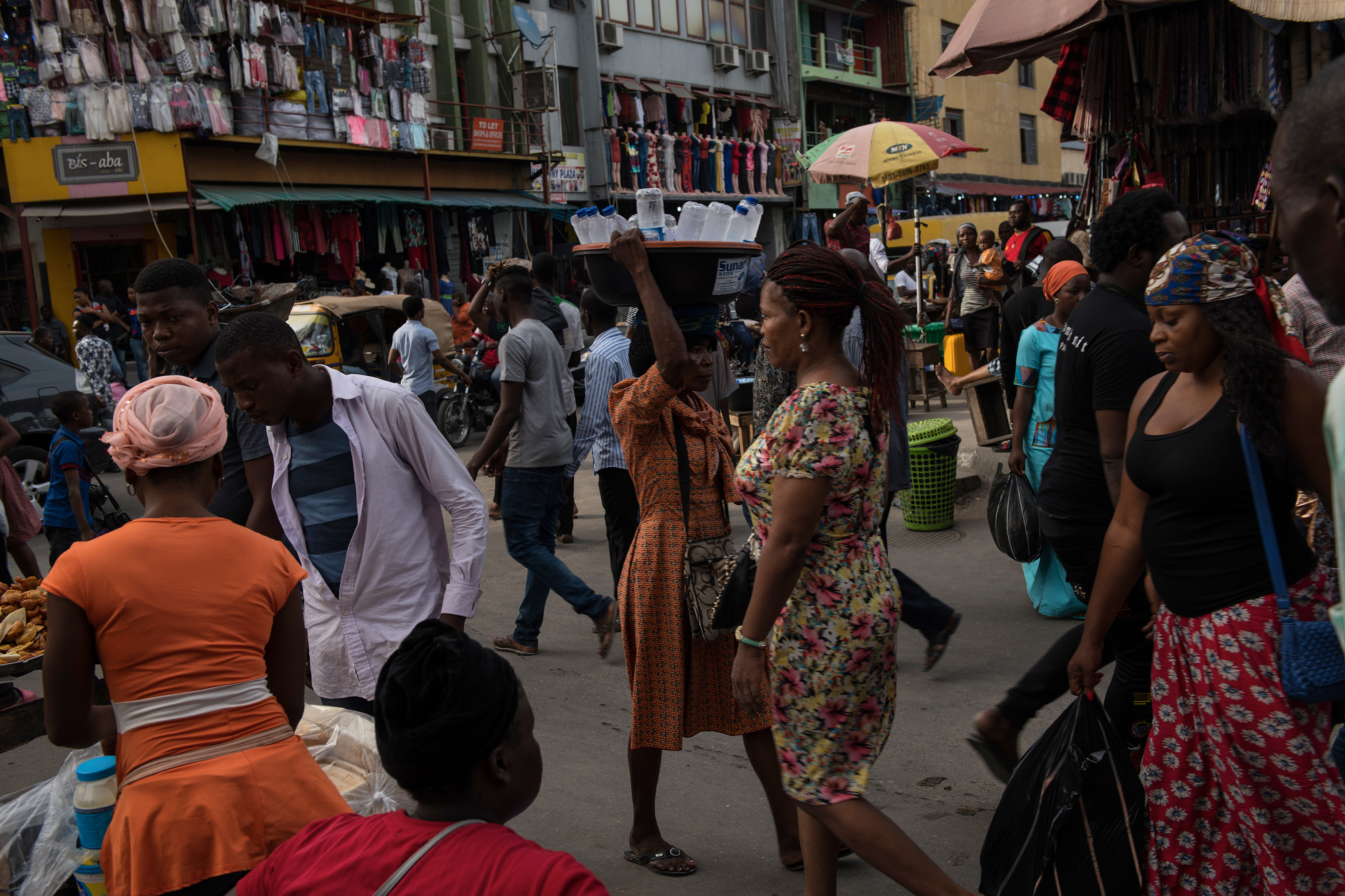 Nigerians walk through the market in Lagos, Nigeria, March 20, 2018 (Lynsey Addario for TIME)