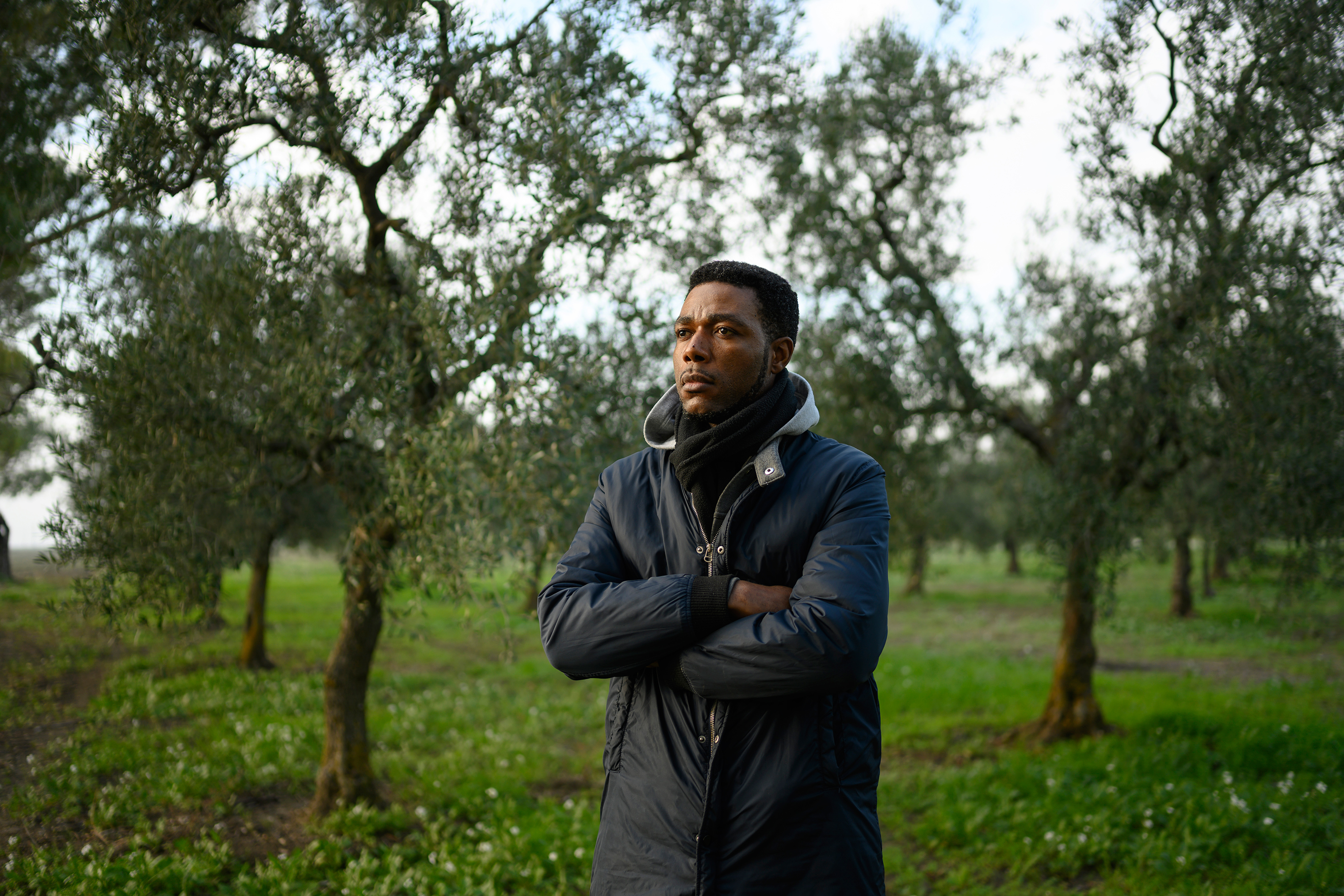 Sagnet, 33, an anti-slavery activist from Cameroon who has been living in Italy since 2010, stands in the olive groves around Foggia, Italy, Dec. 4, 2018. (Lynsey Addario for TIME)