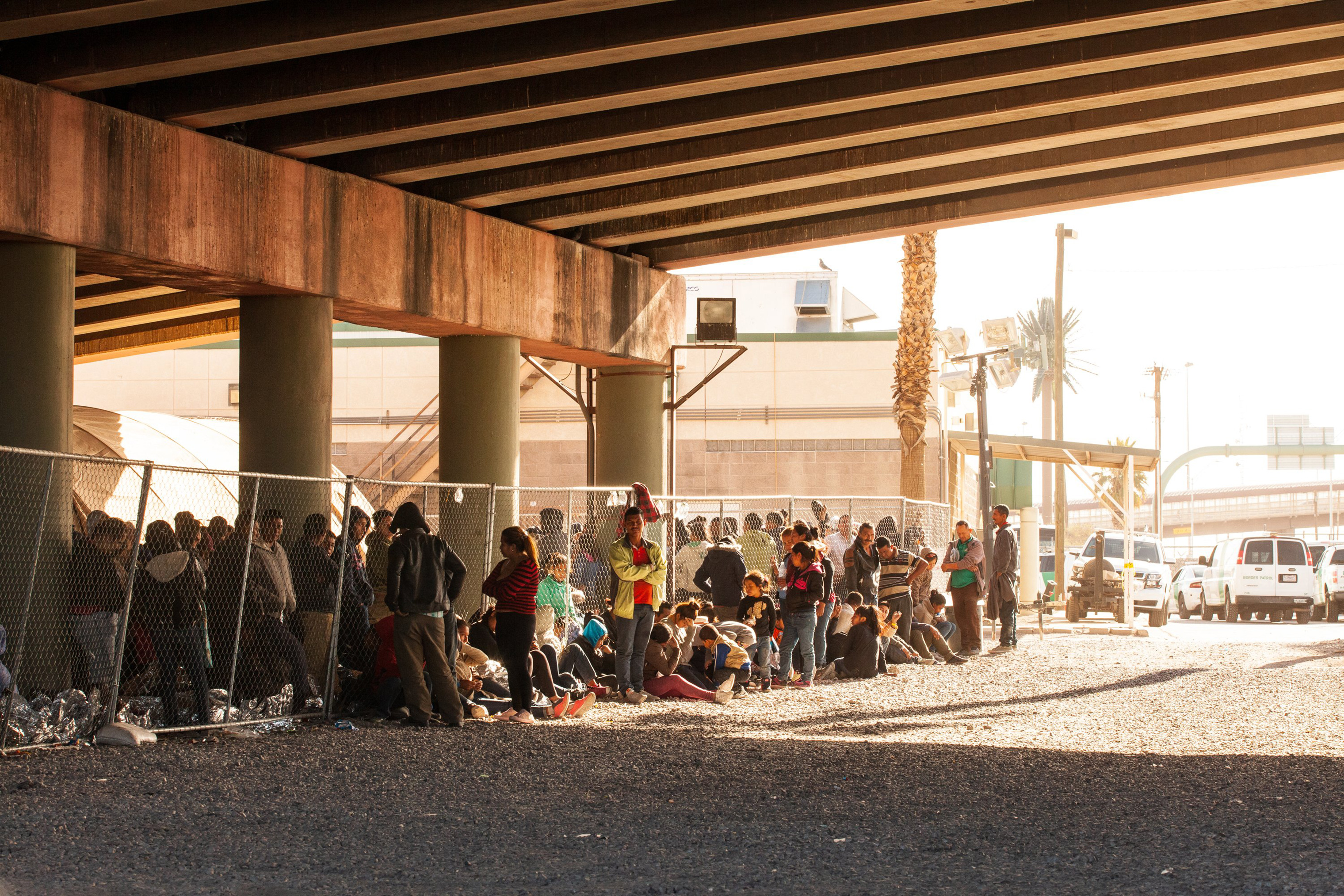 Migrants held in temporary fencing underneath the Paso Del Norte Bridge await processing on March 28, 2019 in El Paso, Texas. (Christ Chavez—Getty Images)