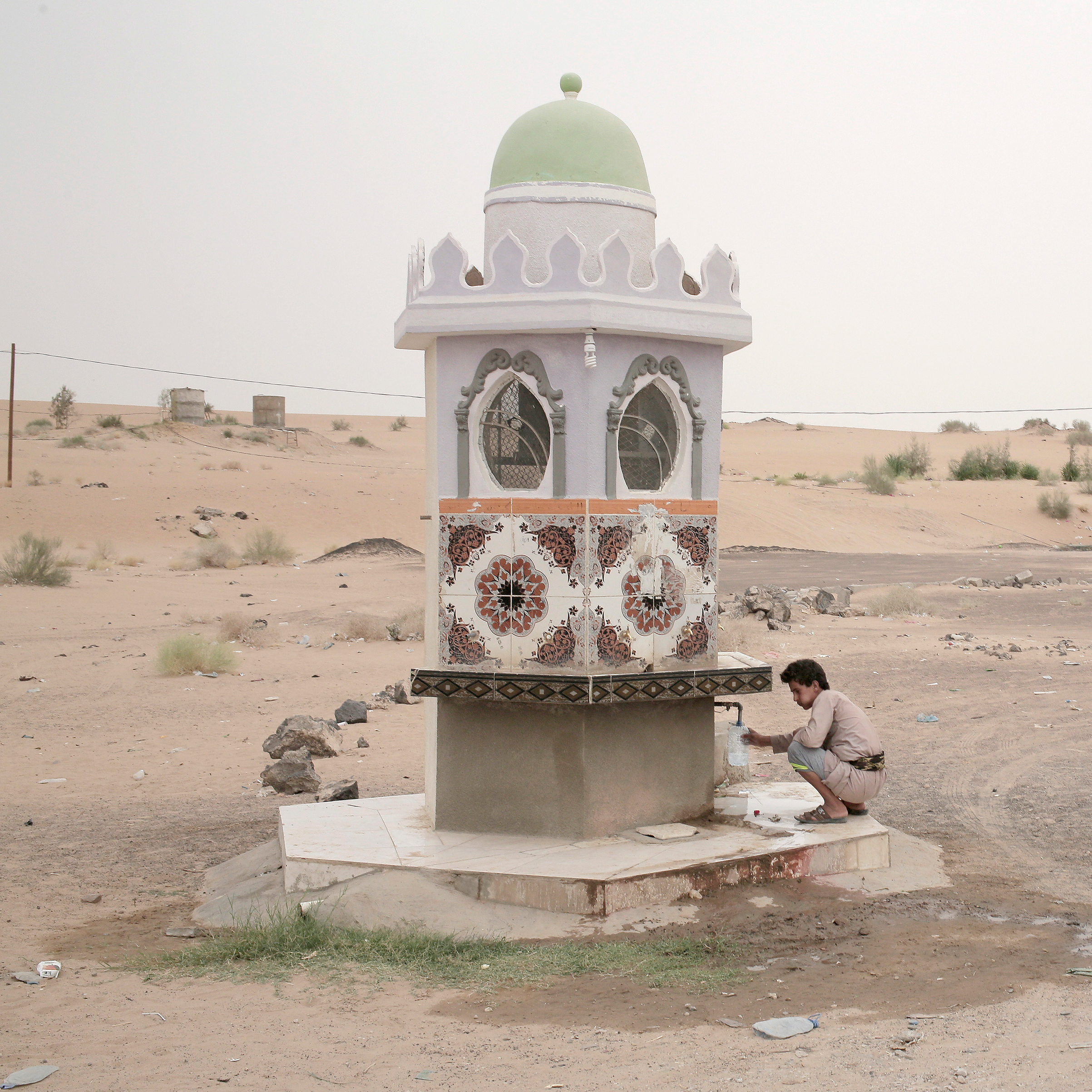 A boy collects water from a roadside fountain in Marib on July 29. (Nariman El-Mofty—AP)