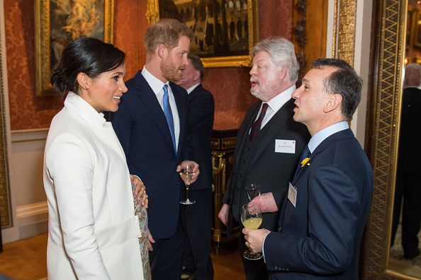 Meghan, Duchess of Sussex Duke and Prince Harry, Duke of Sussex meet Simon Weston and Alun Cairns (R) as they attend a reception to mark the fiftieth anniversary of the investiture of the Prince of Wales at Buckingham Palace in London on March 5, 2019. (Dominic Lipinski—WPA Pool/Getty Images)