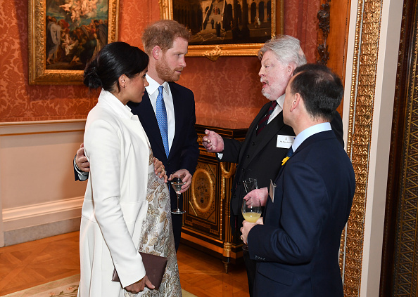 Meghan, Duchess of Sussex Duke and Prince Harry, Duke of Sussex meet Simon Weston and Alun Cairns (R) as they attend a reception to mark the fiftieth anniversary of the investiture of the Prince of Wales at Buckingham Palace in London on March 5, 2019. (Dominic Lipinski—WPA Pool/Getty Images)